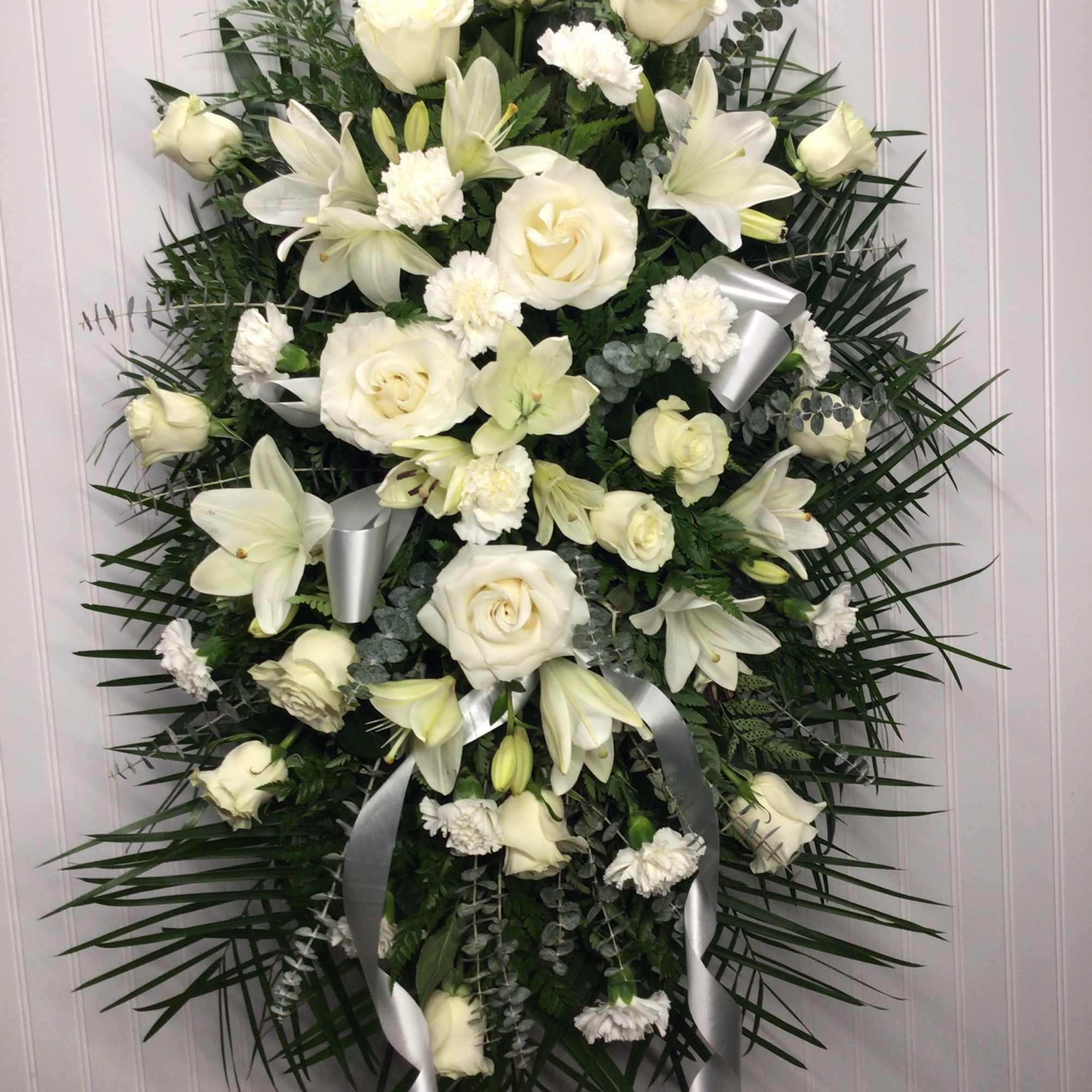 Beautifully simple this lovely spray of white roses lilies and carnations decorated