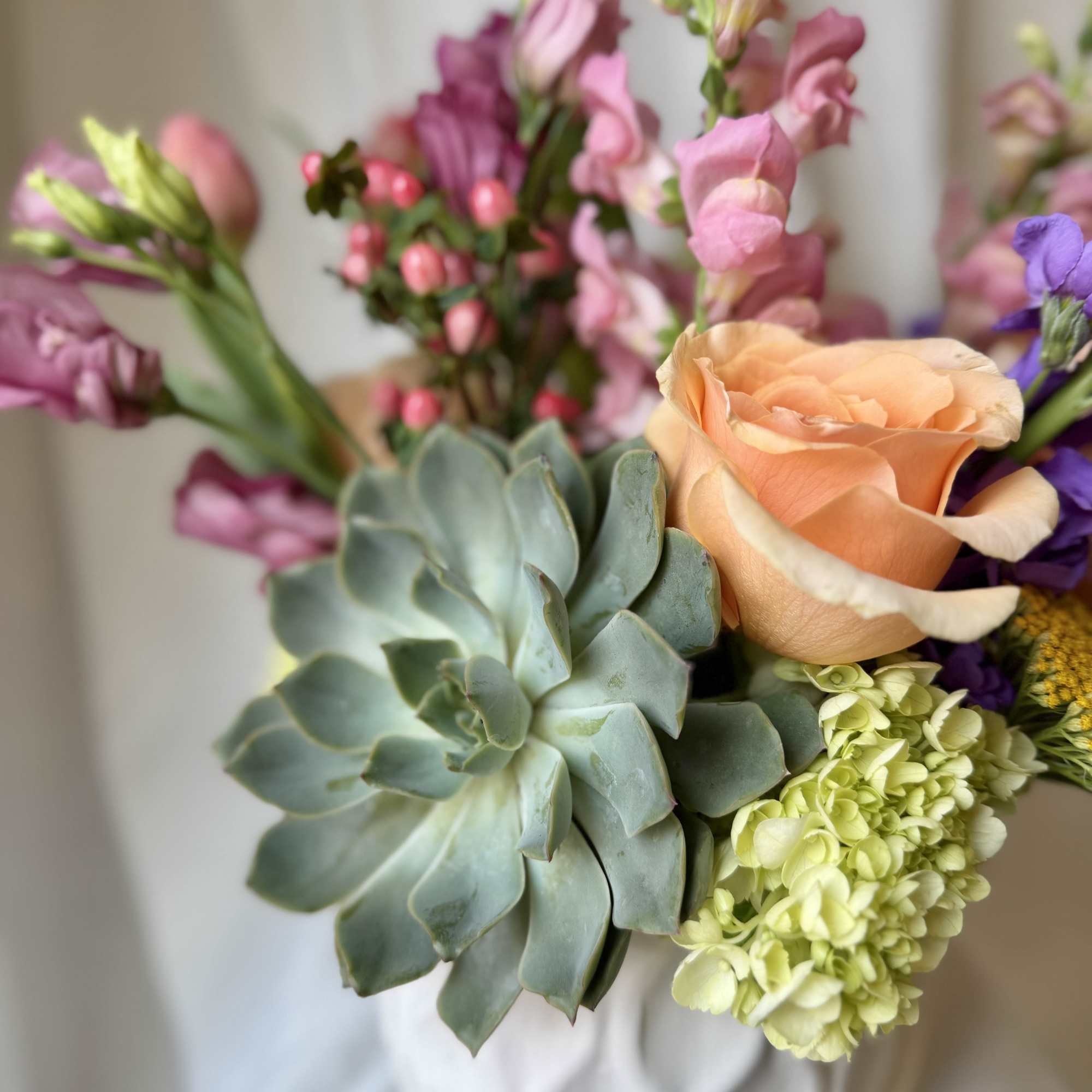 Bouquet with peach rose, pink snapdragons, and a blue-green succulent