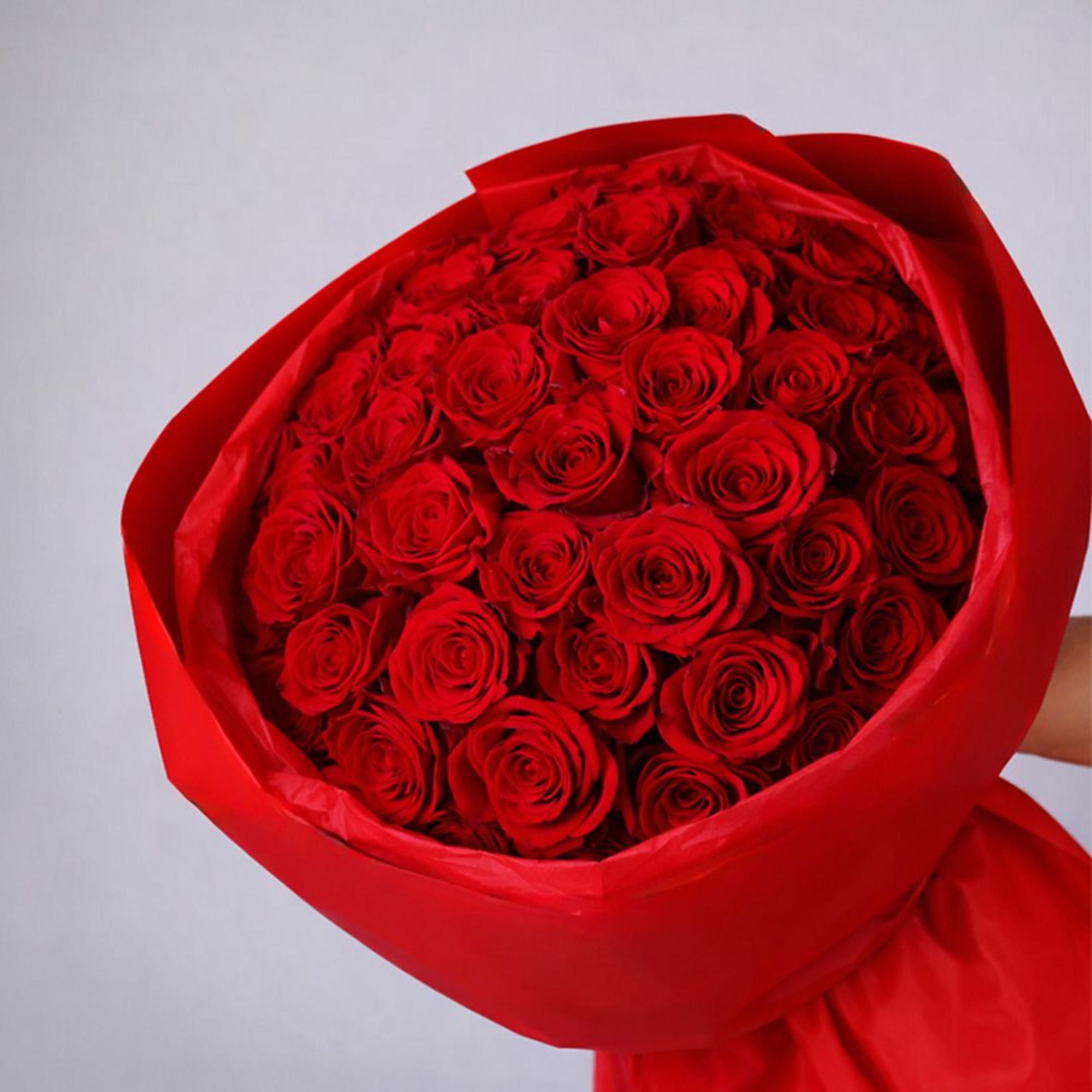 Bouquet of red roses wrapped in red paper