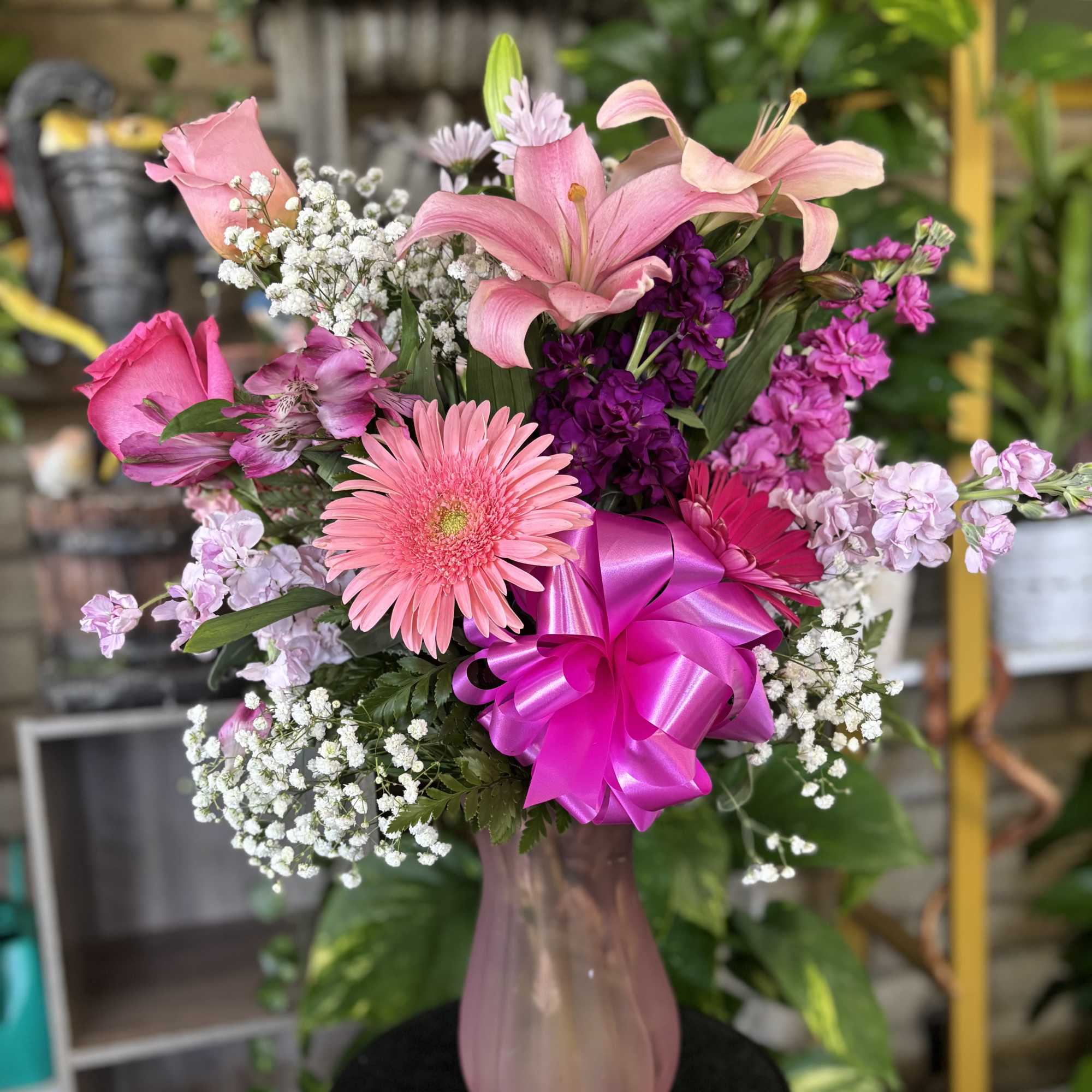 Pink bouquet with lilies, gerbera daisy, and a bright ribbon in a vase