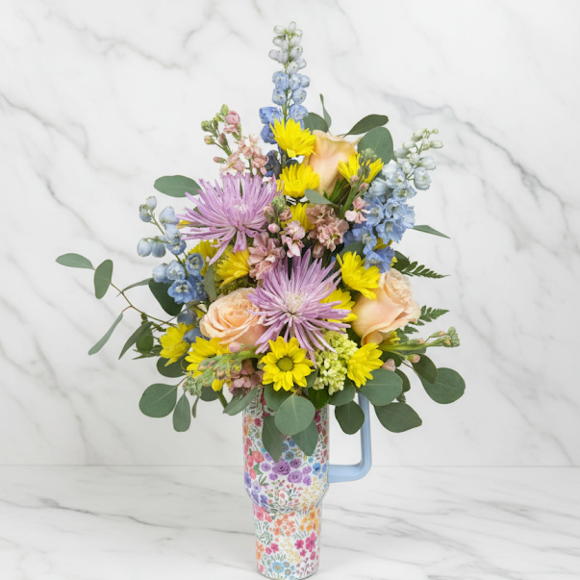Mixed bouquet in a floral-patterned mug vase