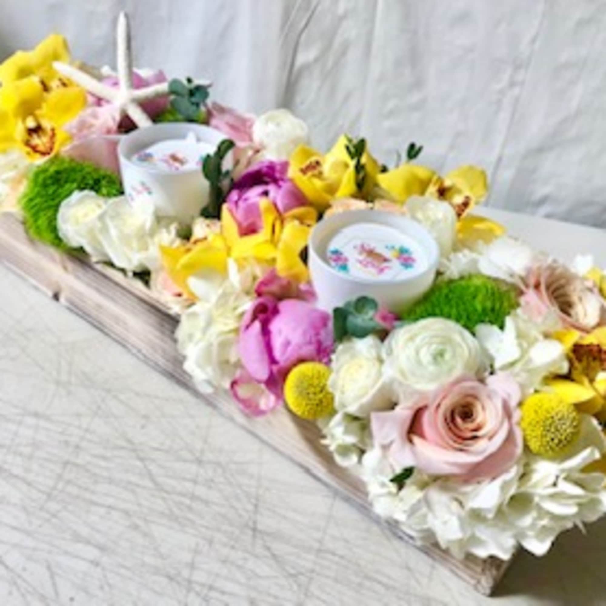 Rectangular floral arrangement with candles and bright yellow orchids