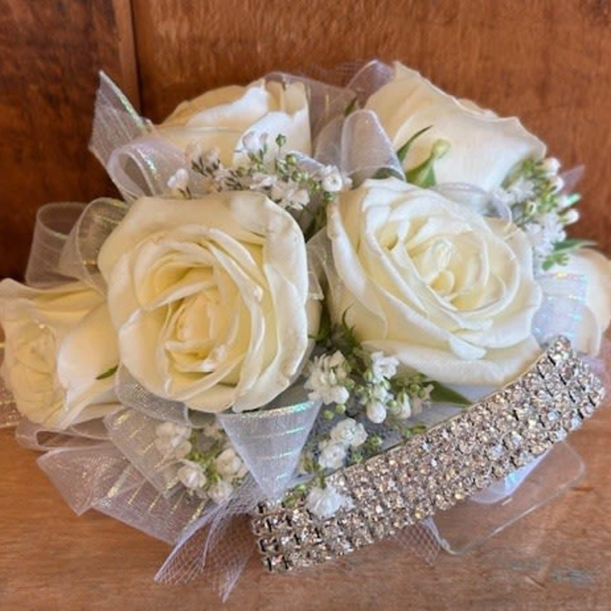 A classic corsage with matching sheer ribbon, this wristlet looks good with