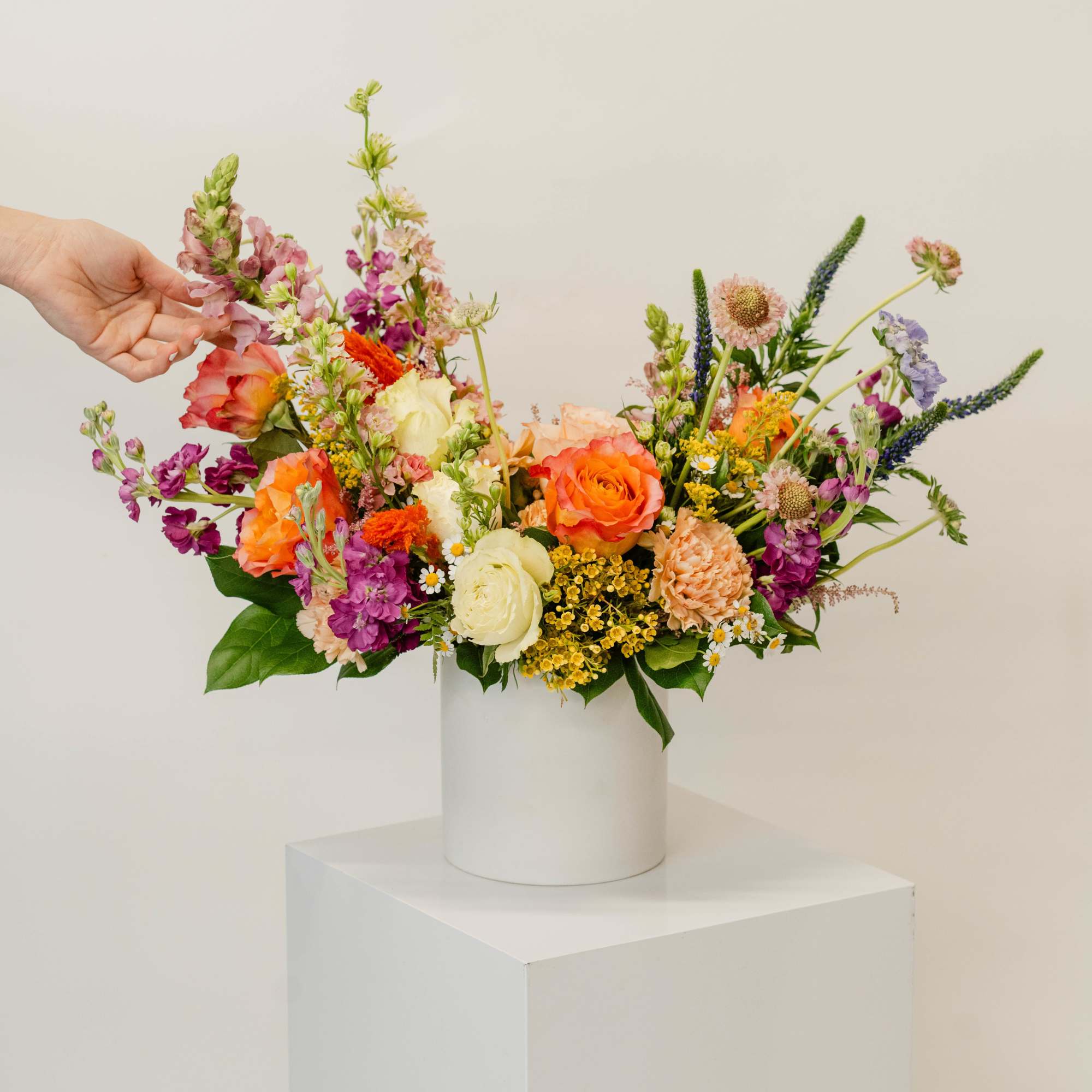 Colorful mixed bouquet in a white cylindrical vase