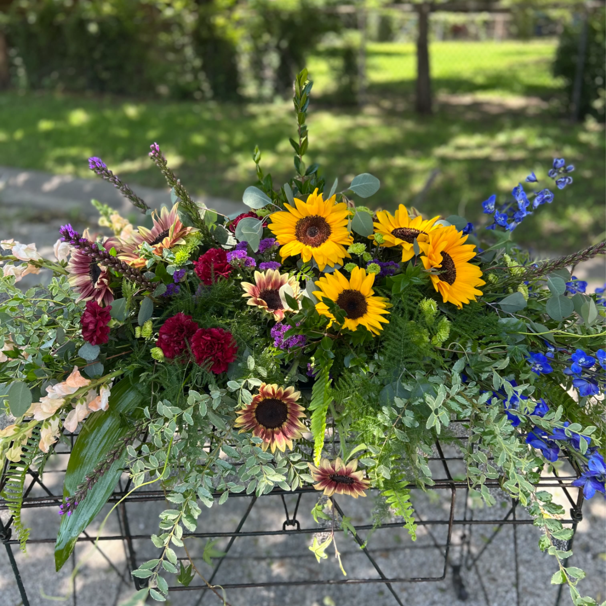 This casket spray is filled with a wide variety of flowers and
