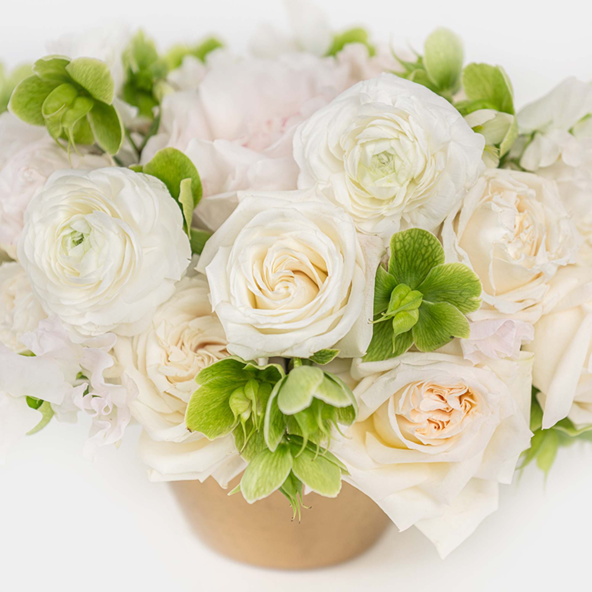 Structured yet effortlessly chic, this monochrome arrangement of roses, ranunculus, sweet peas