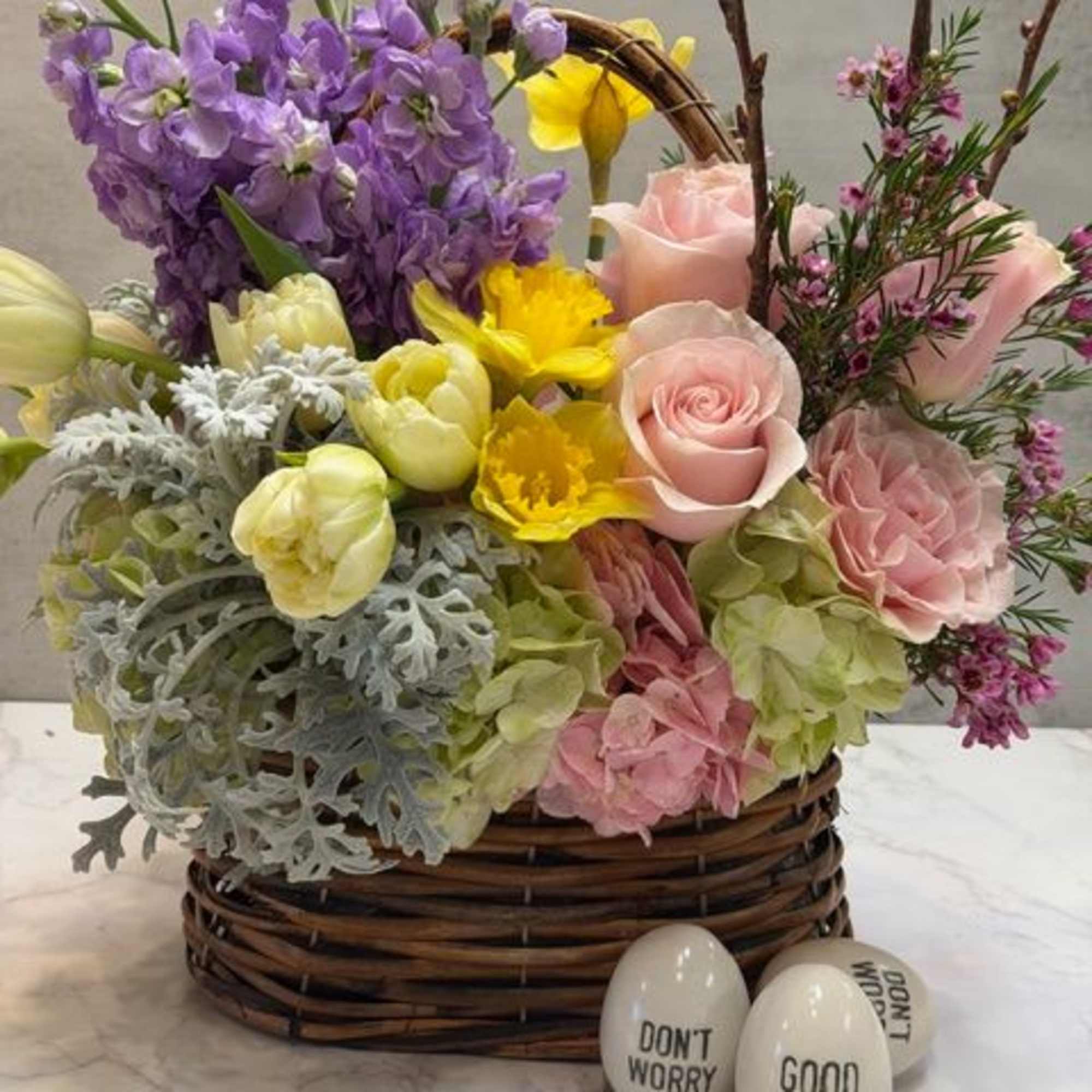 Beautiful small basket measuring 5" long, filled with spring blooms such as