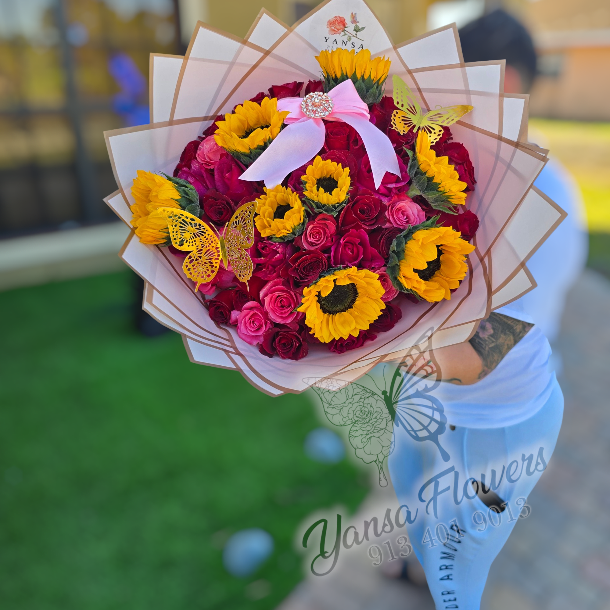 The breathtaking arrangement of 50 roses mixed with vibrant sunflowers, wrapped in
