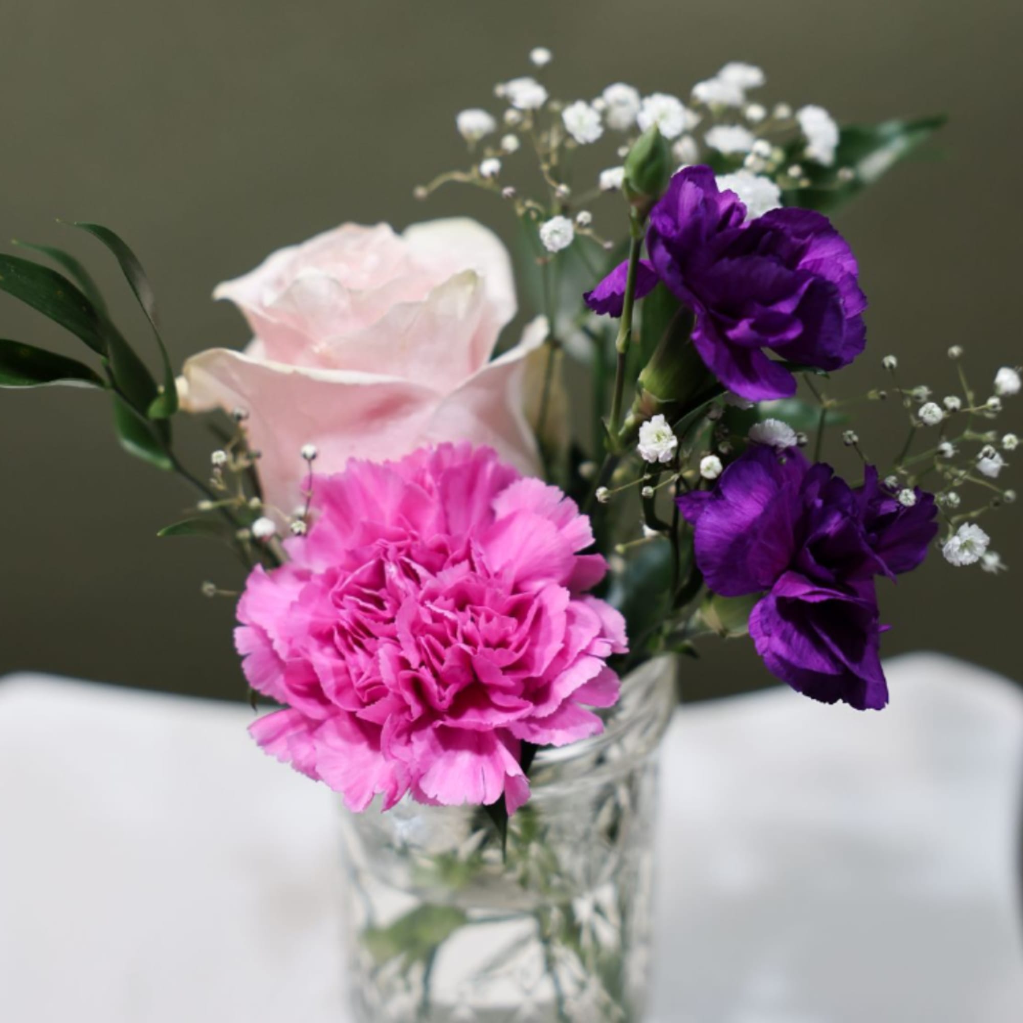 Charming seasonal flowers arranged in classic mason jars create a relaxed, rustic