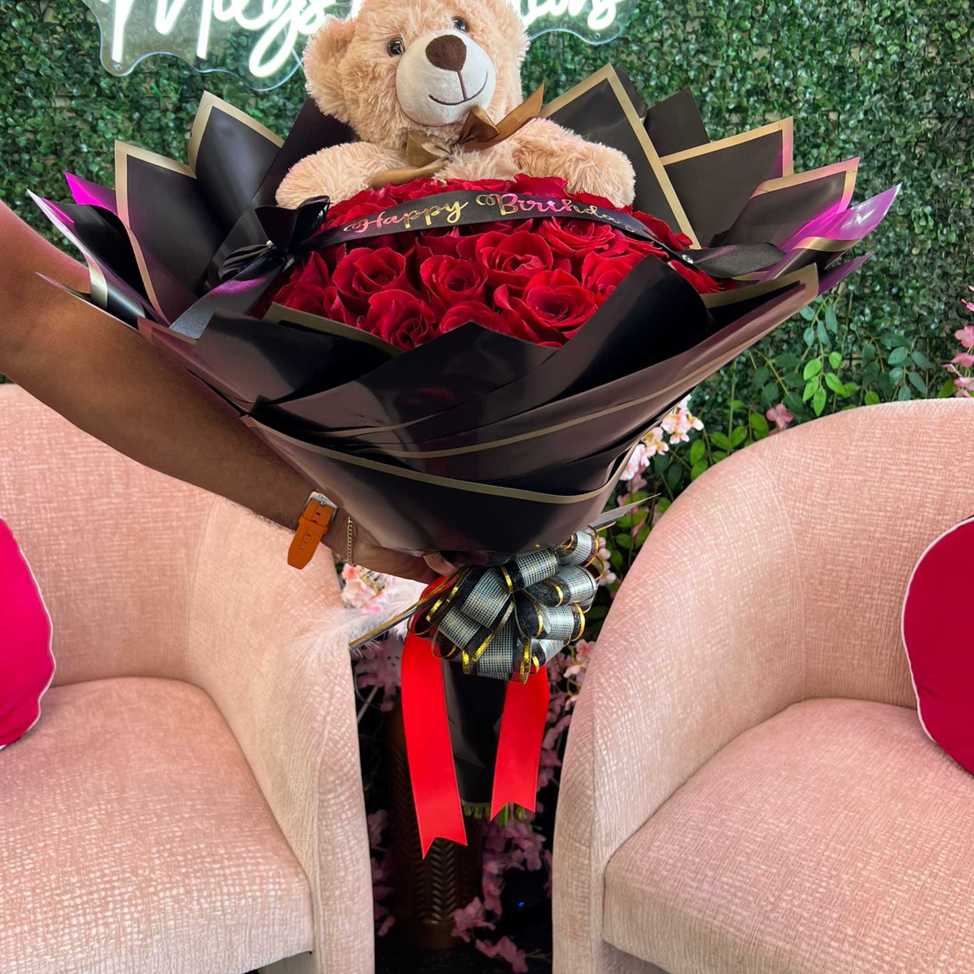 Bouquet of red roses with a teddy bear and ribbon wrap