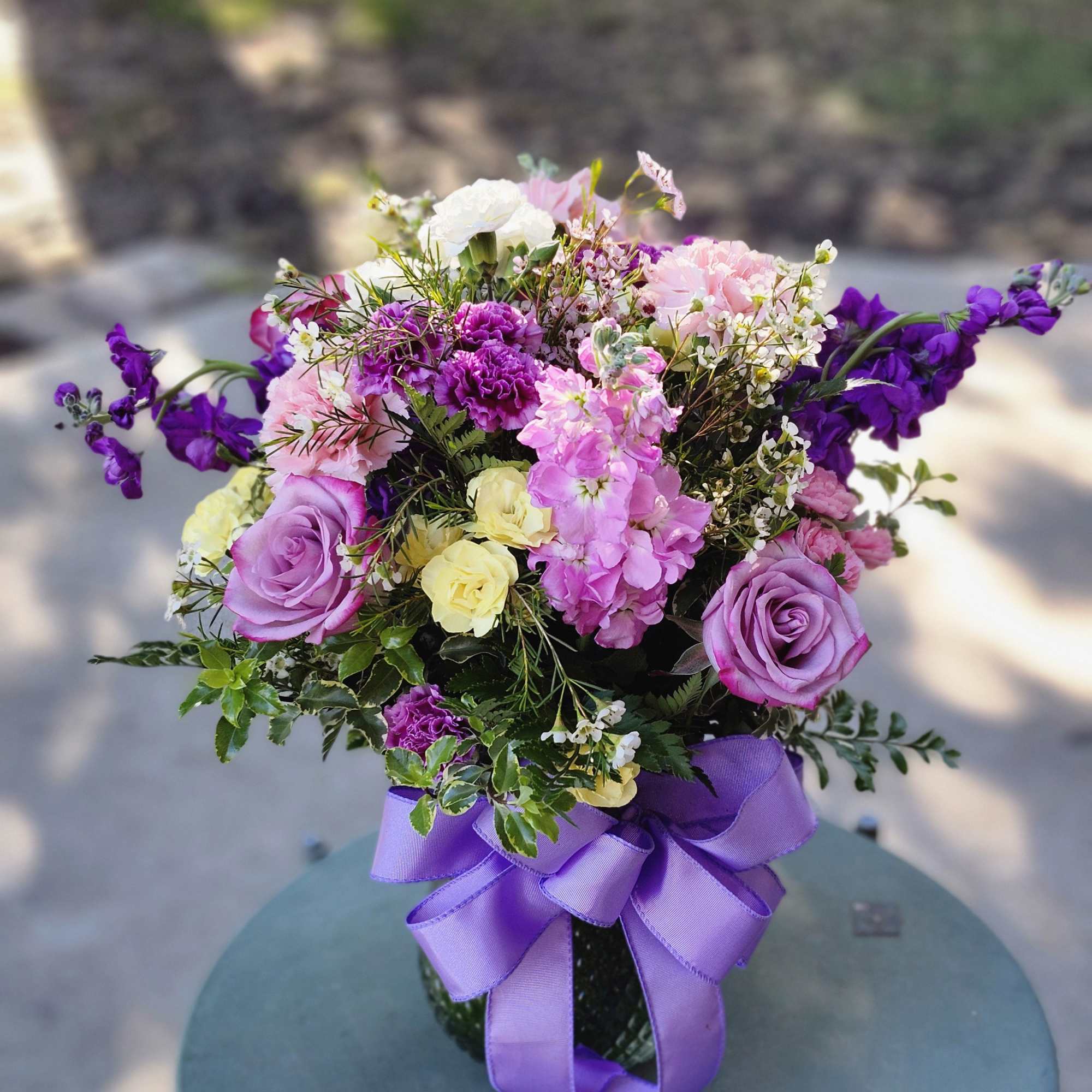 Colors of purple, lavender, yellow and white. Combination of Roses, stock and