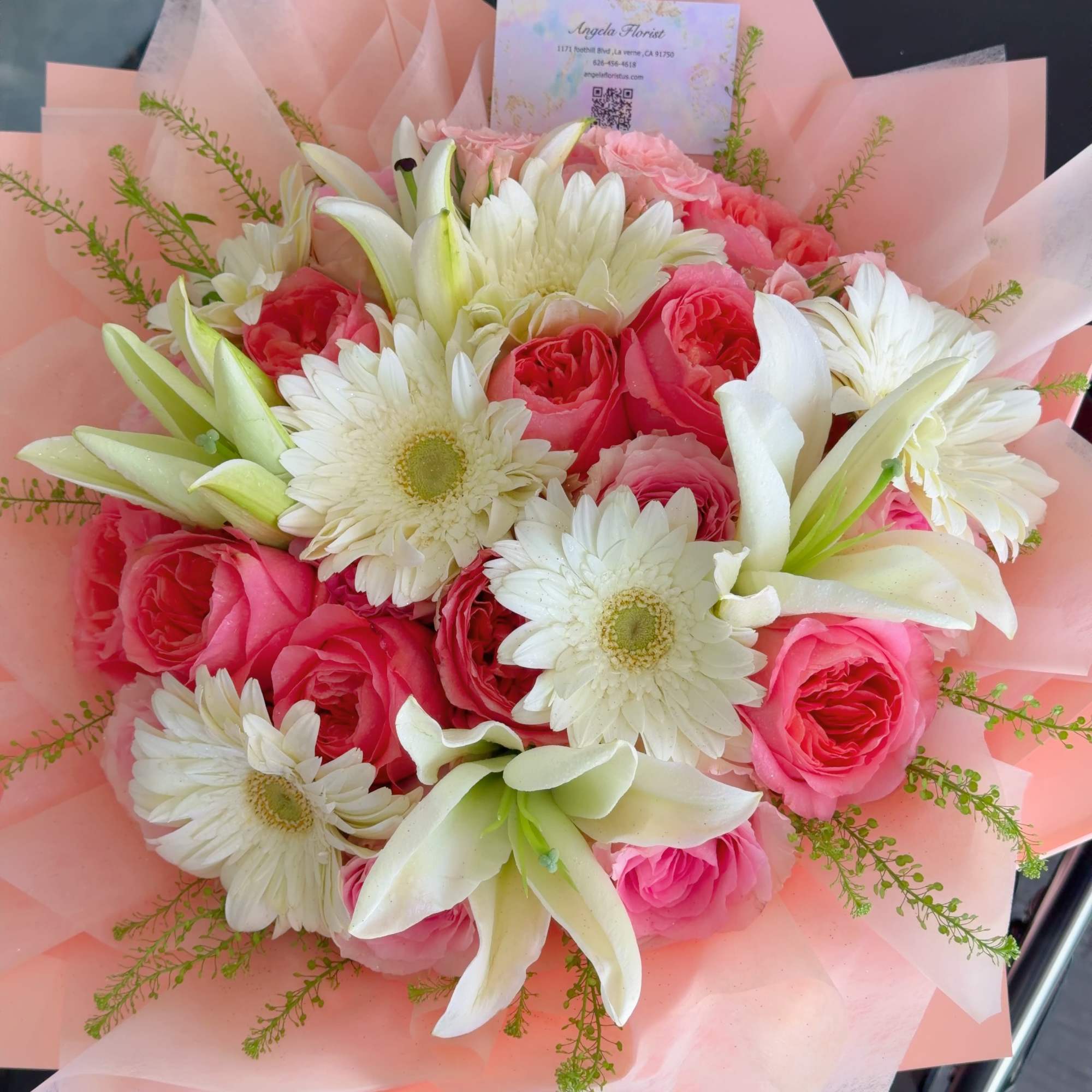 A charming bouquet of soft pink roses, white lilies, and fresh gerbera