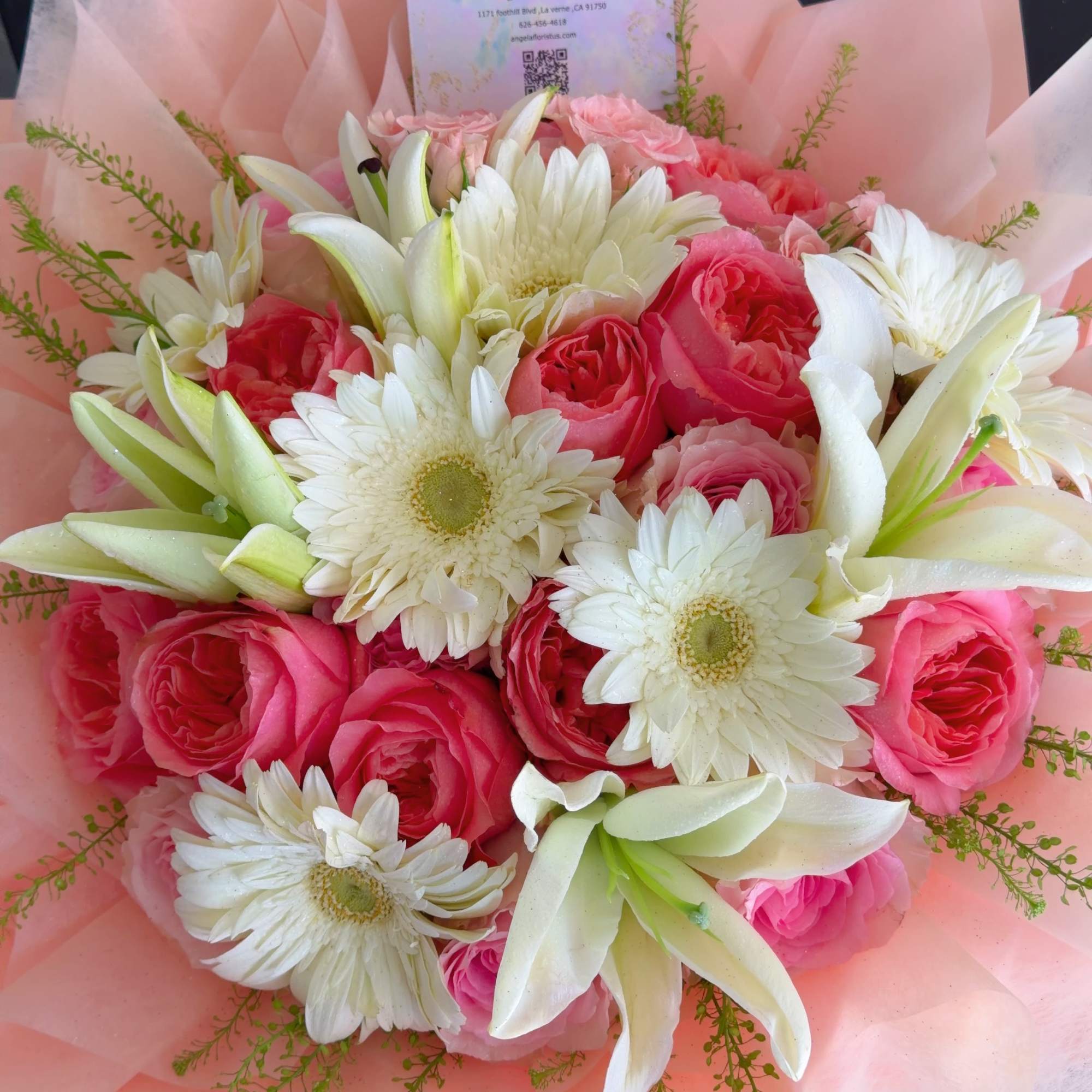 A charming bouquet of soft pink roses, white lilies, and fresh gerbera