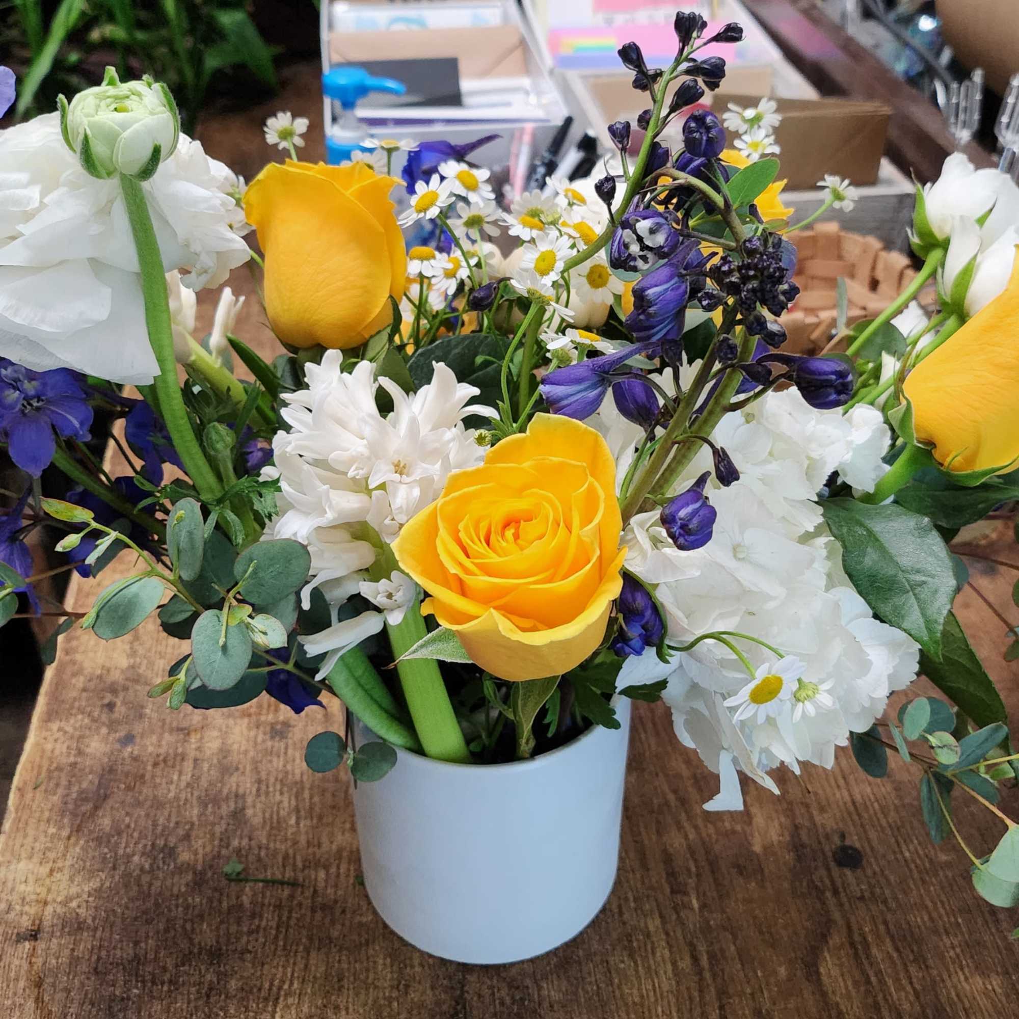 Fresh Blue delphinium and white flower arrangement touch with yellow