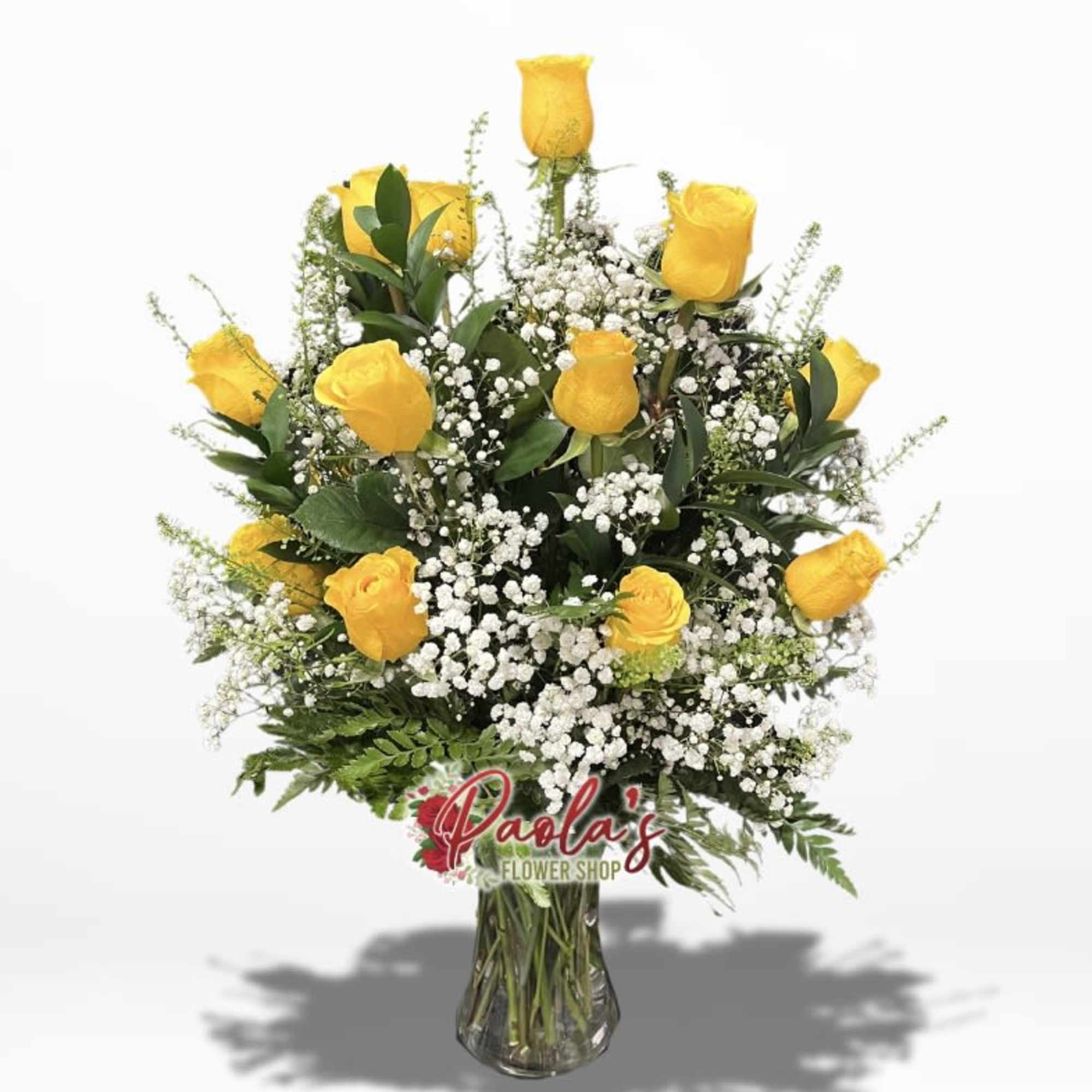 Yellow roses in a clear glass vase with white filler flowers