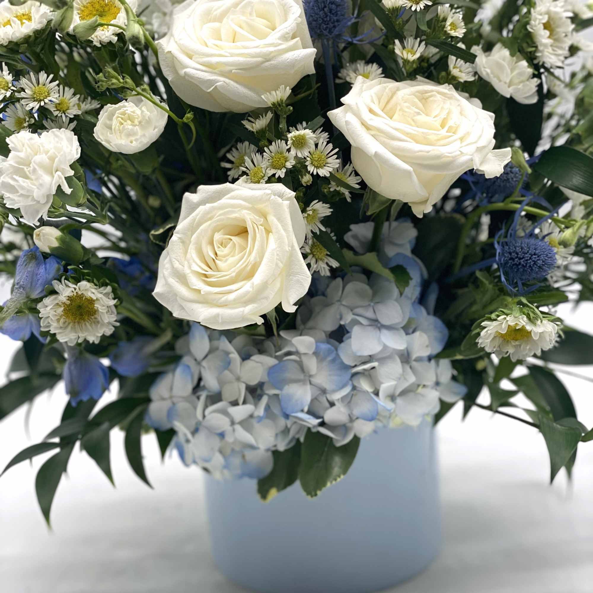 A mix of blue &amp; white blooms designed in a light blue