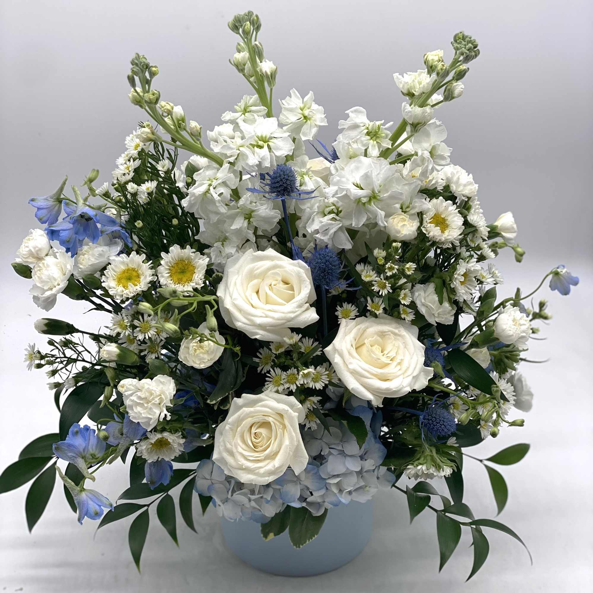 A mix of blue &amp; white blooms designed in a light blue