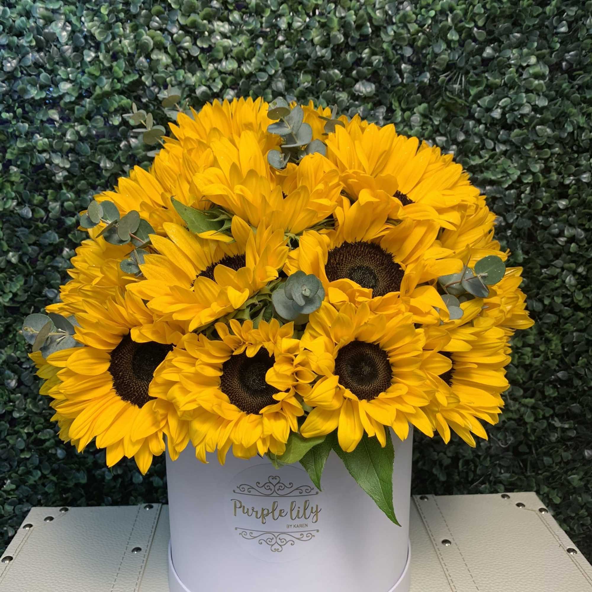 Yellow sunflowers arranged in a white hat box