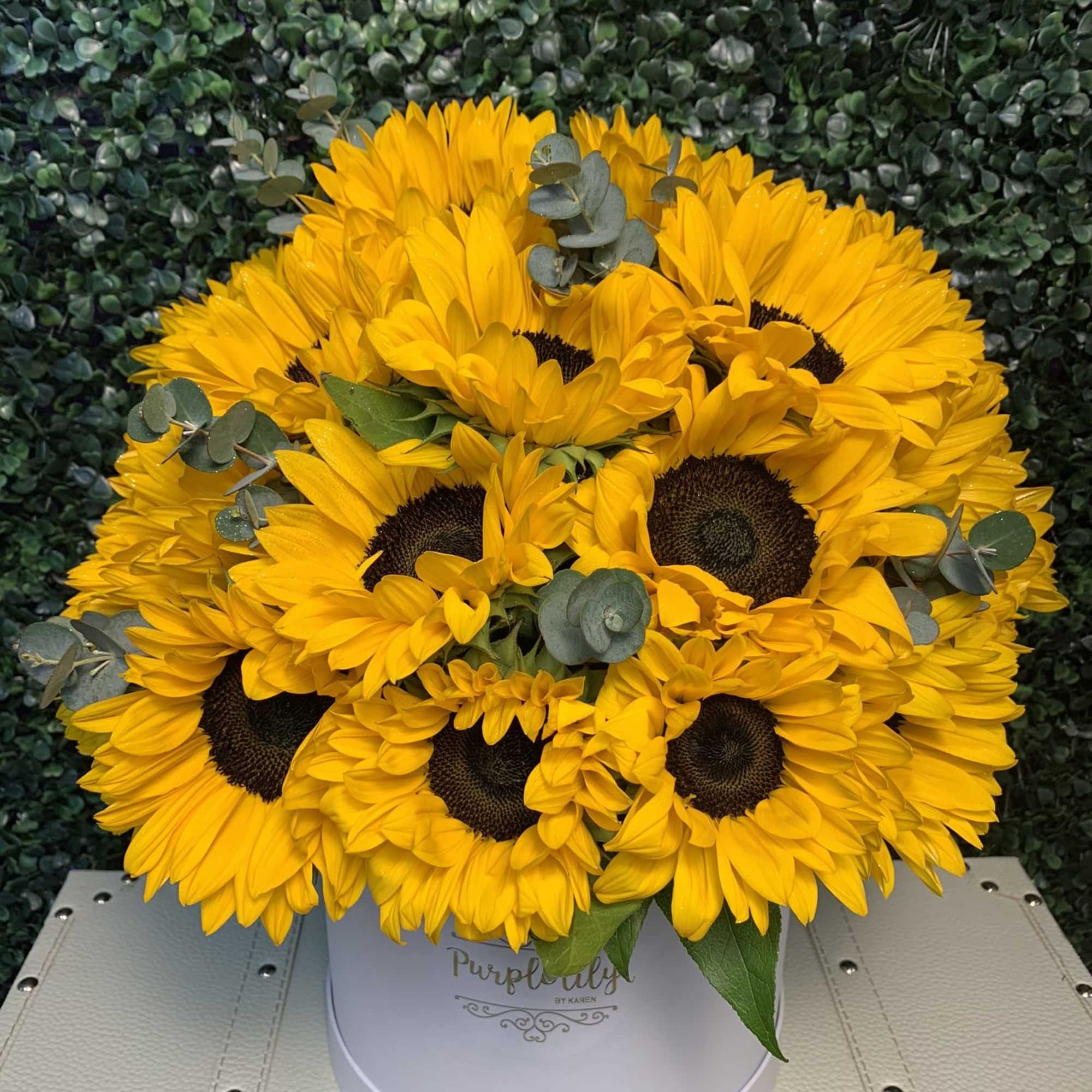 Bouquet of yellow sunflowers in a white round box
