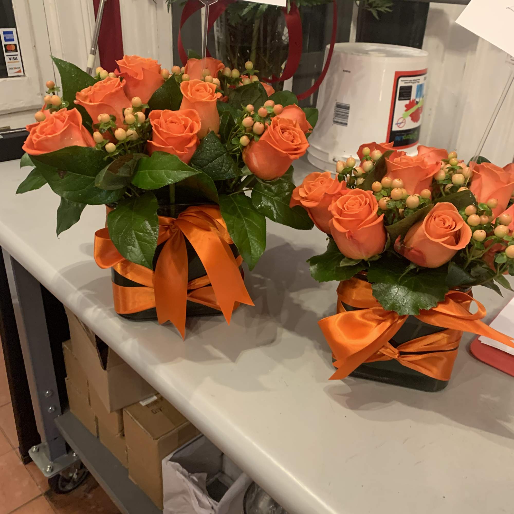 Orange roses mixed with hypericum in a simple cube
also: available in red