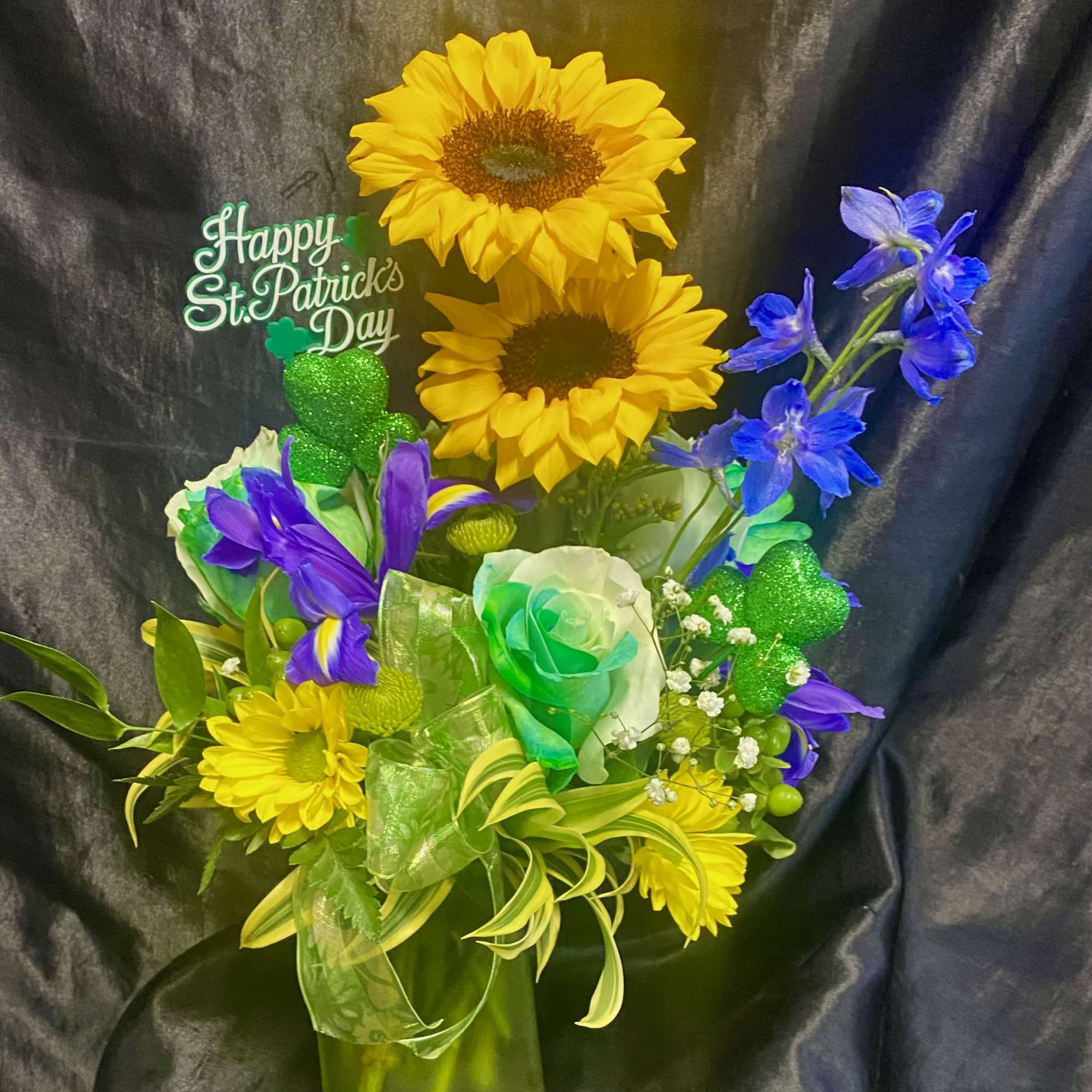 Green themed.  With sunflower,  roses. blue delphinium etc  