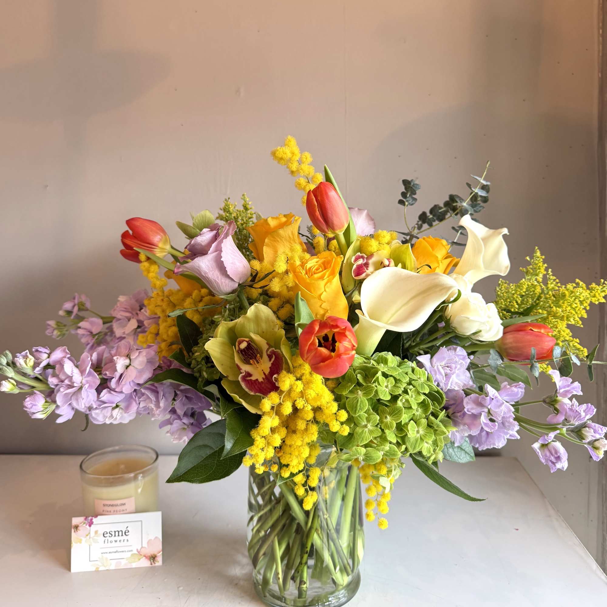 A cheerful arrangement consisting of bright Spring flowers such as Brighton roses