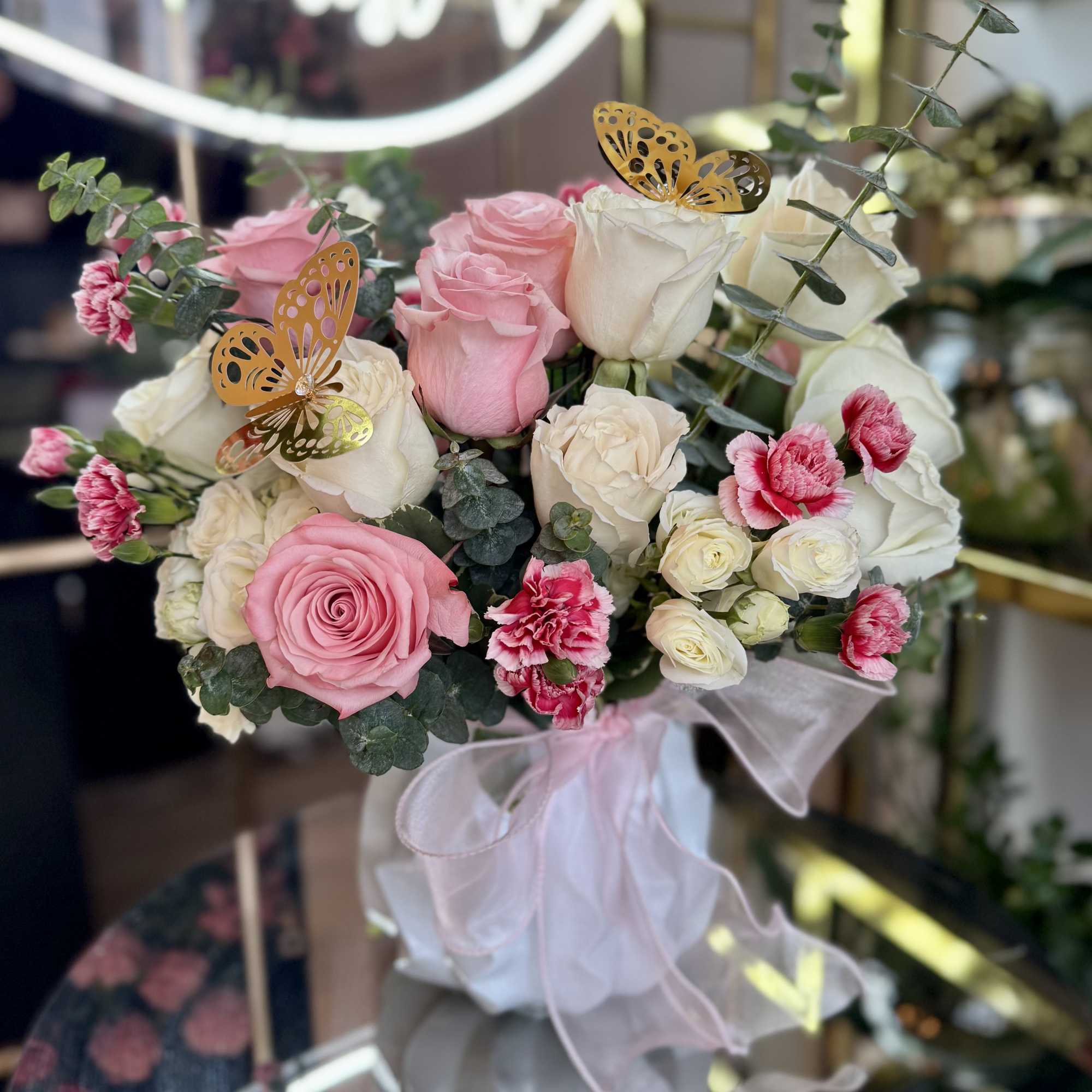 Pink and white rose bouquet with small carnations and butterfly picks
