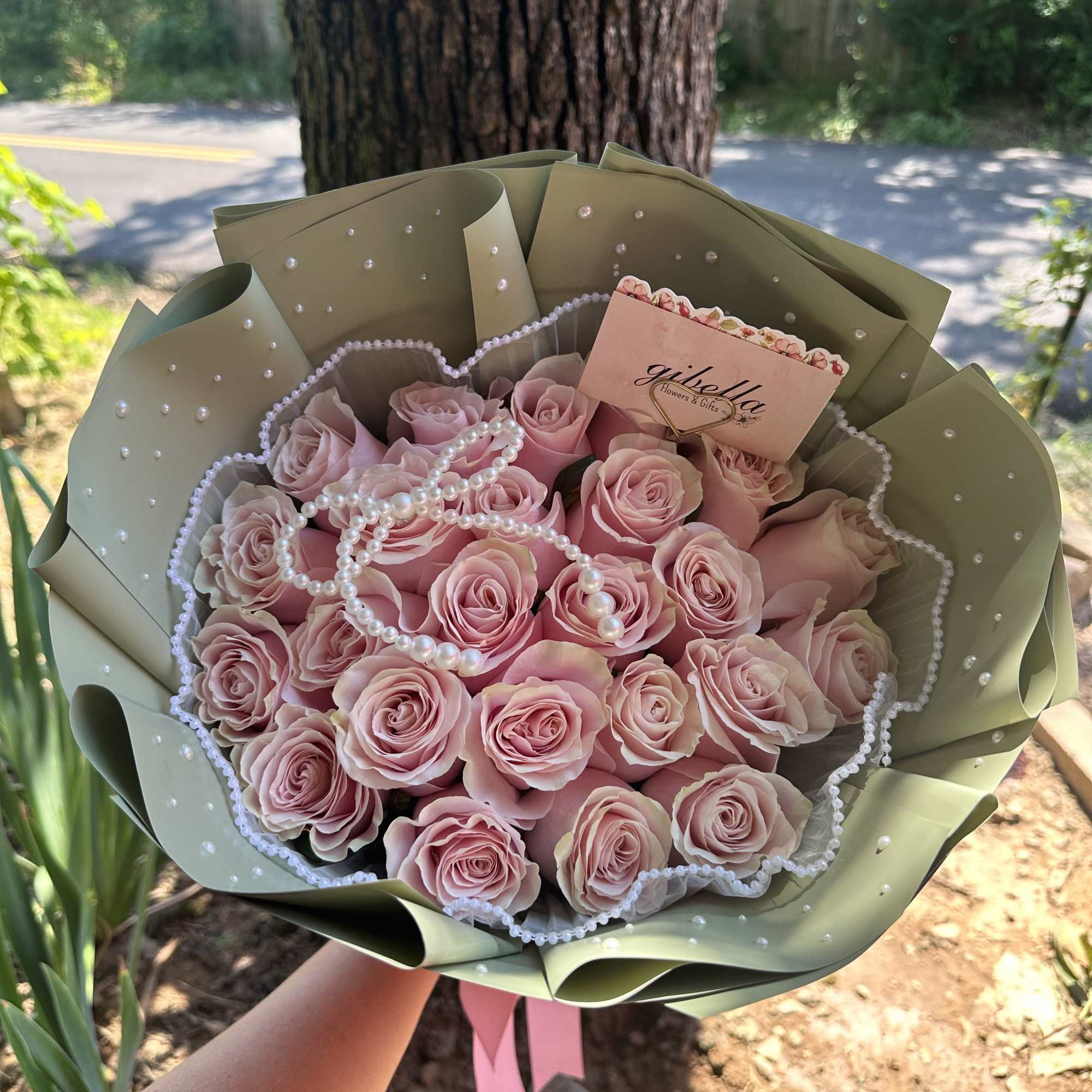 Pink rose bouquet wrapped in sage paper with pearl accents