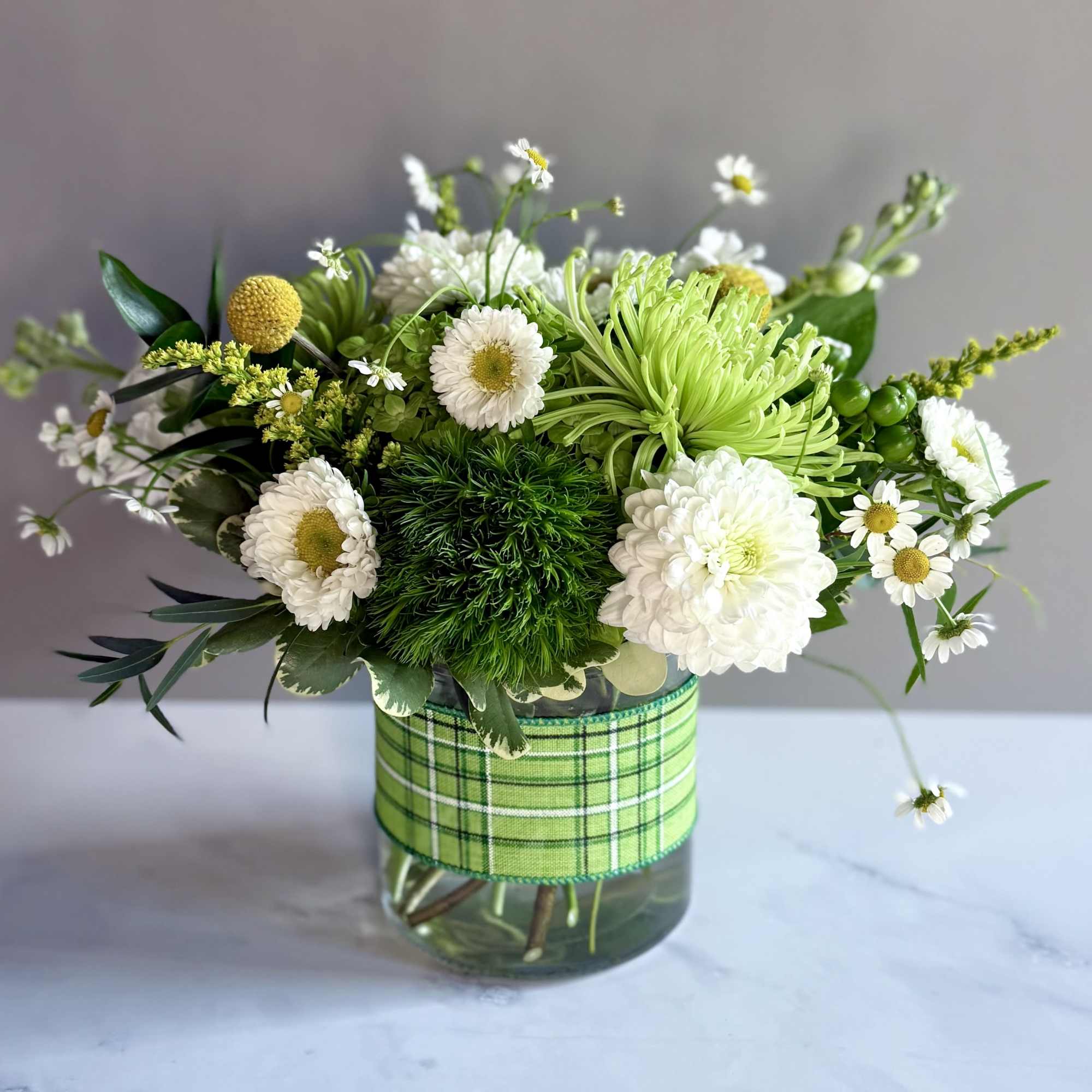A cylinder arrangement of spring green flowers! Mixed with some white and