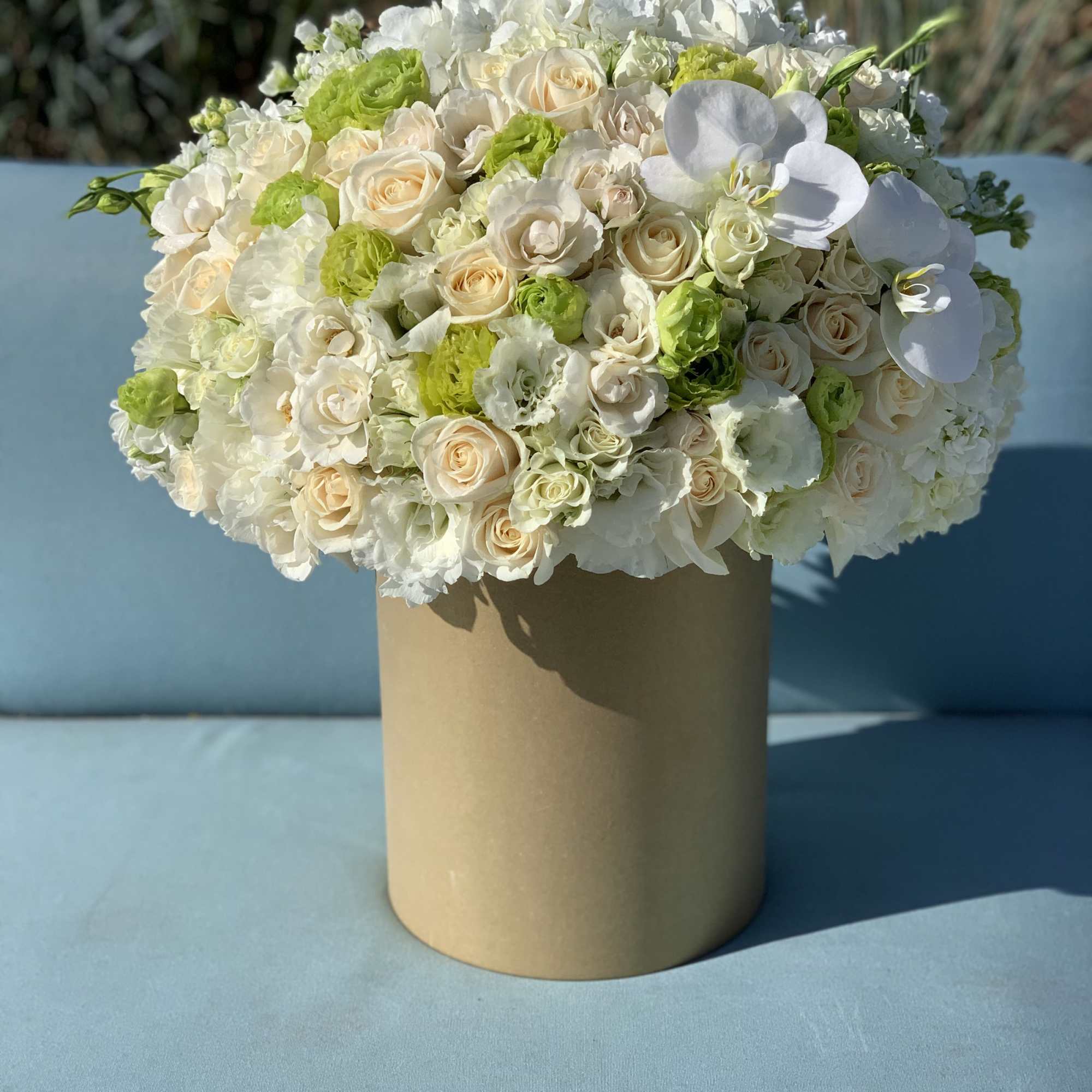 White and cream rose bouquet in a tan cylindrical box