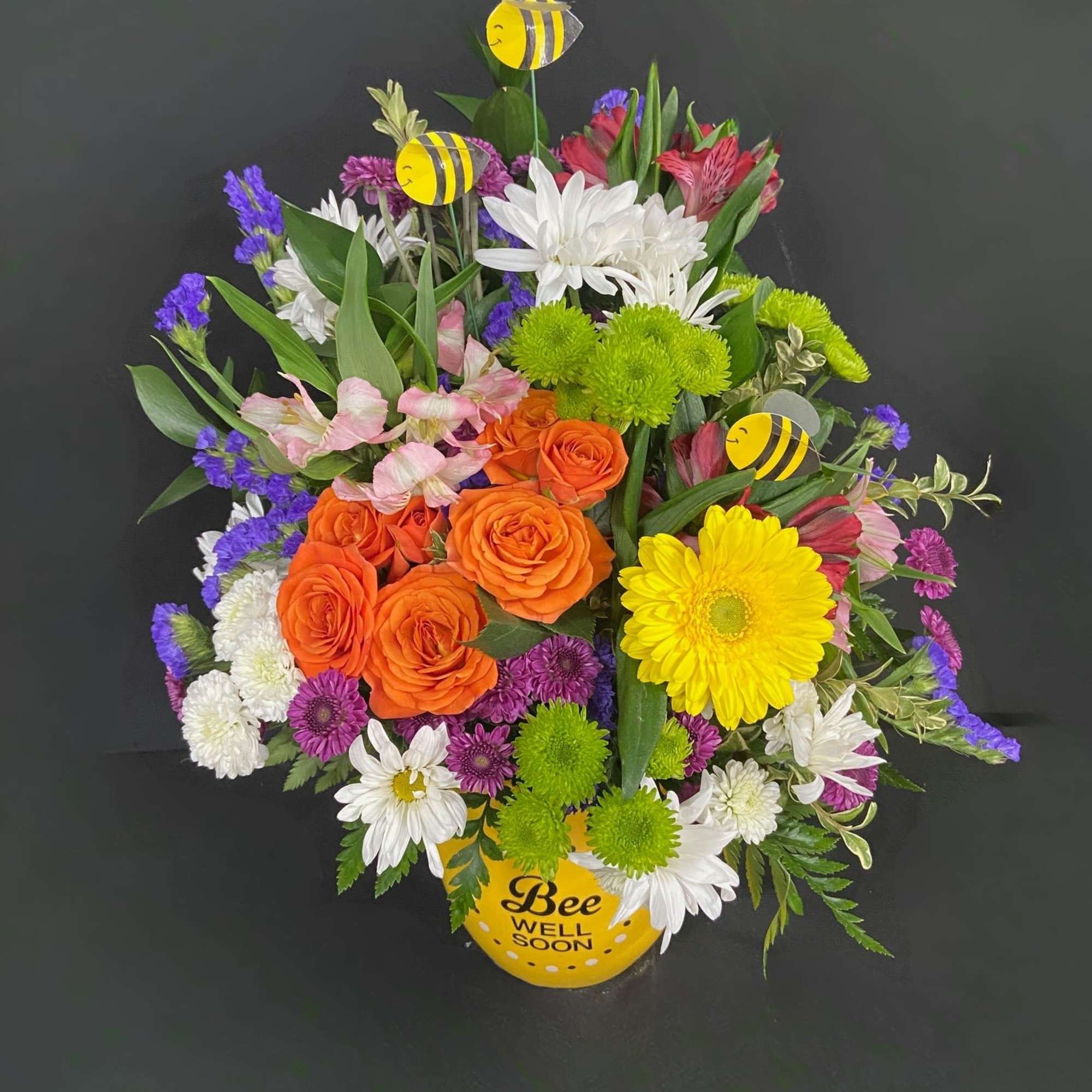 Tiny bees float among a vibrant and beautiful garden of yellow Gerberas