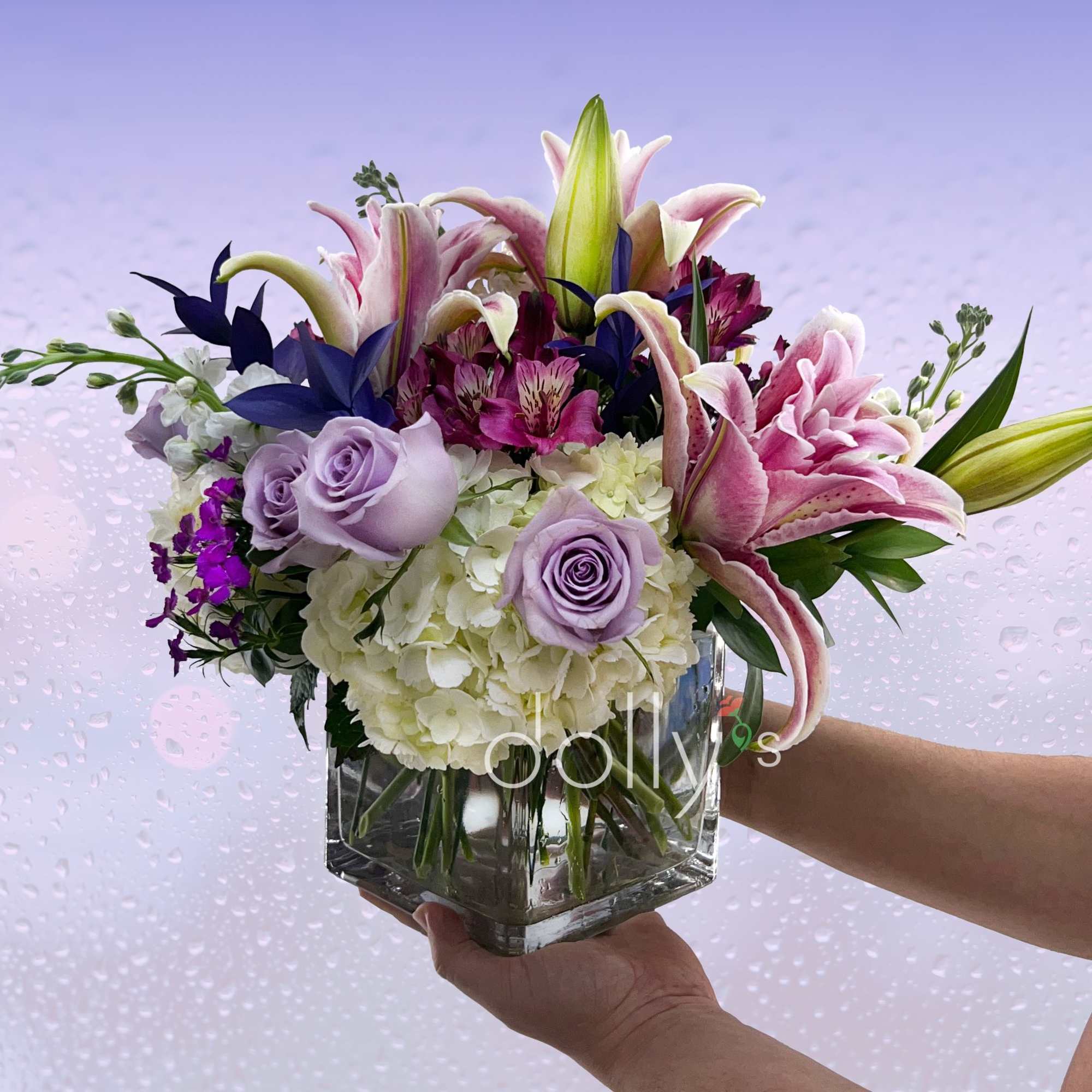 Roses, lilies, and mums in varying hues of purples and lavender.