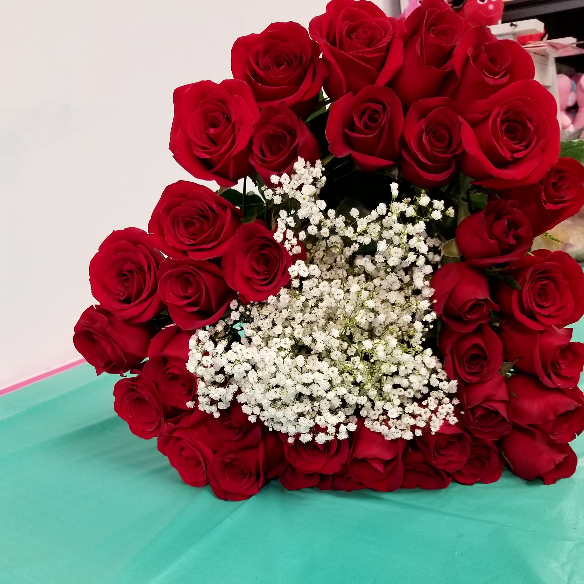 Long stem roses in a heart shaped bouquet tied with a satin