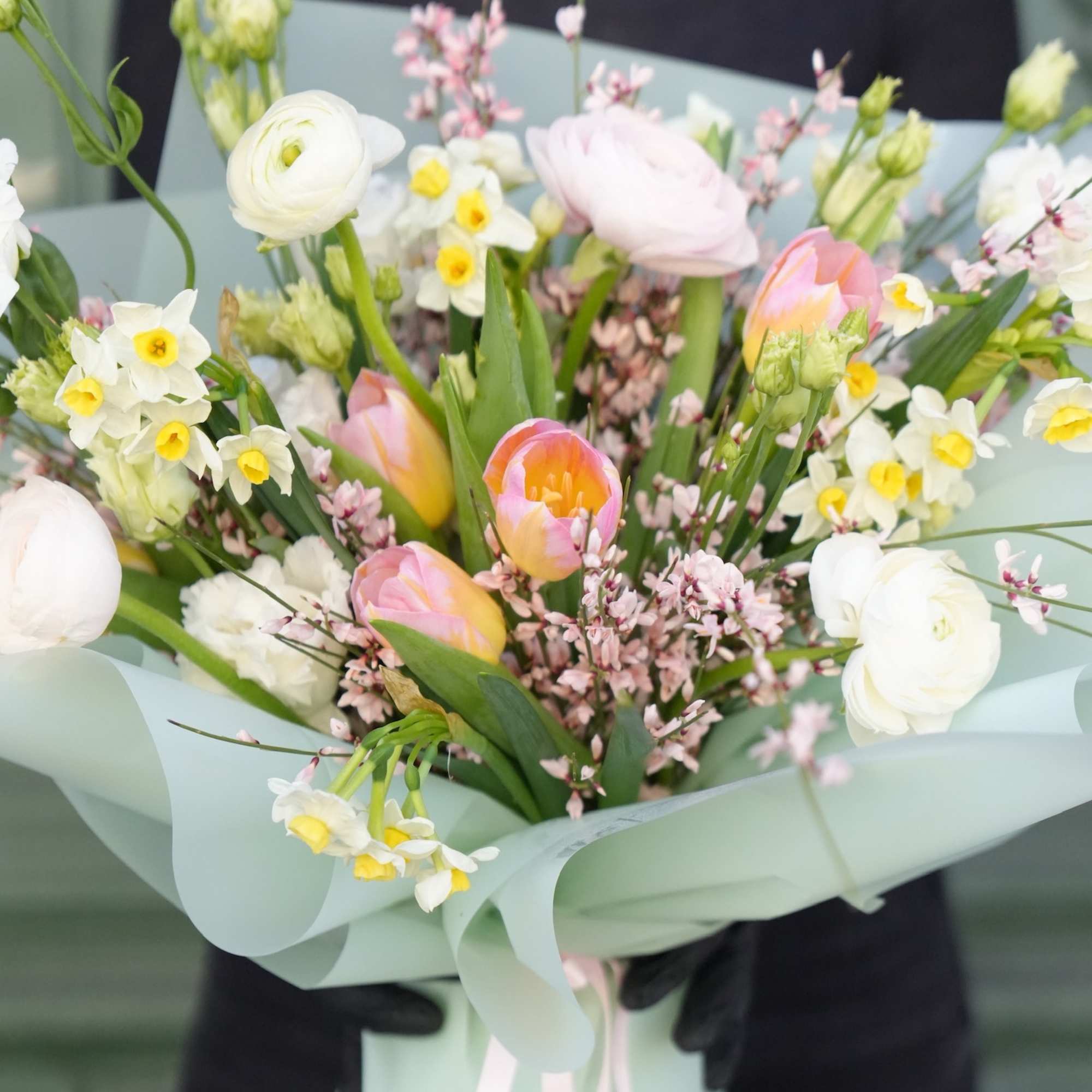 A bouquet made with delicate blooms in various shades of pink, white