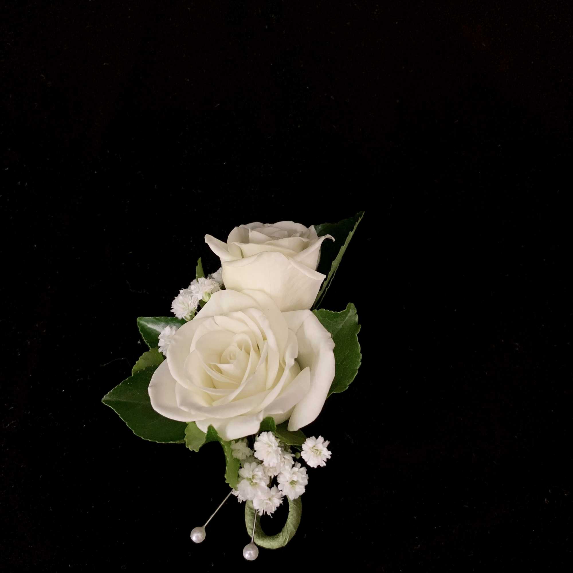 A petite boutonniere featuring two sweetheart roses, pictured in white, but available