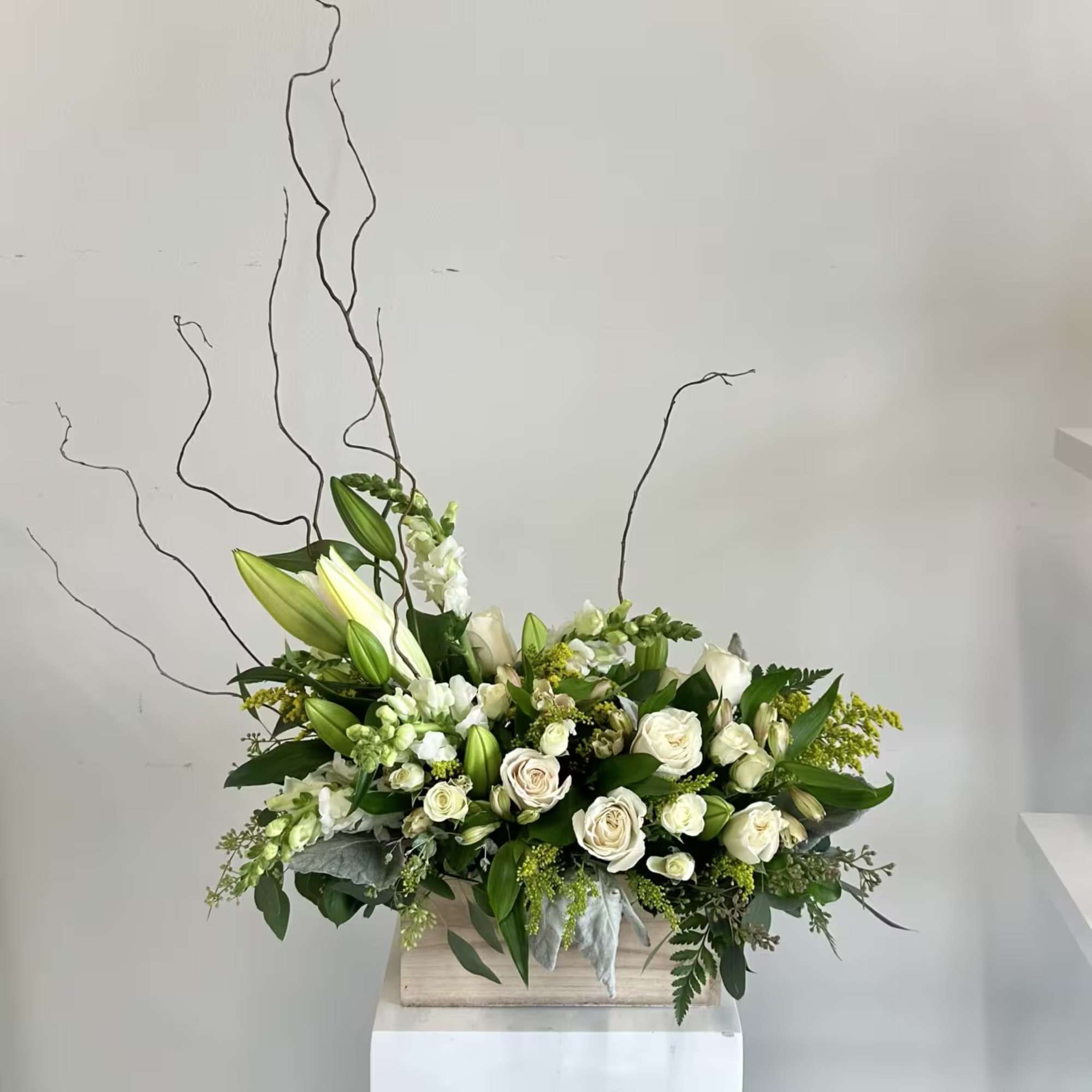 The Always Adored sympathy flower arrangement is a serene, all-white tribute designed