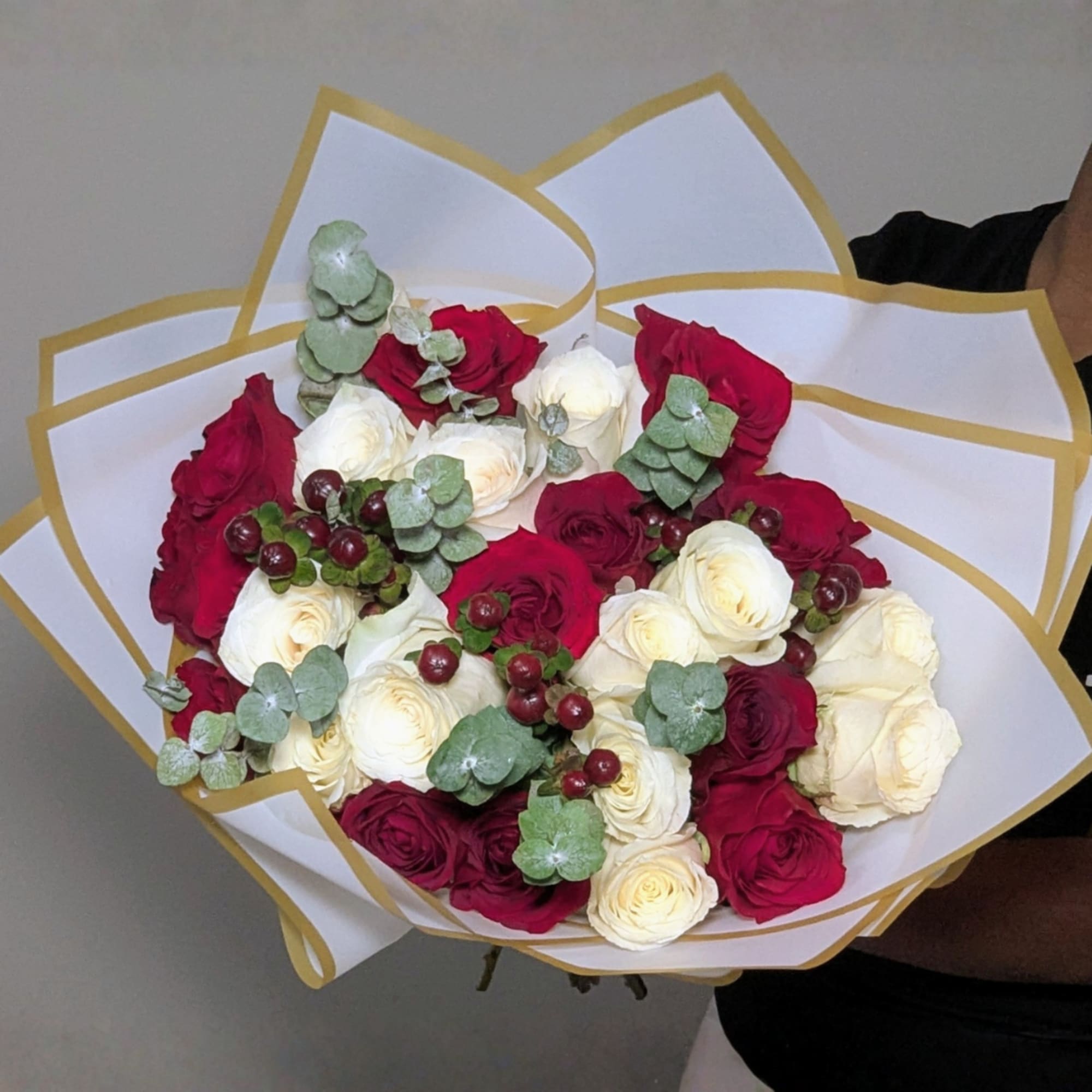 A beautiful hand-tied bouquet featuring 24 premium red and white roses, accented