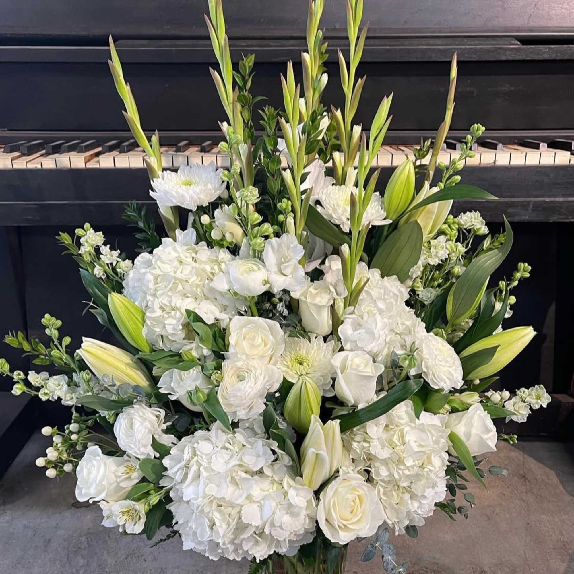 This large arrangement includes mixtures of white florals ideal for all occasions.