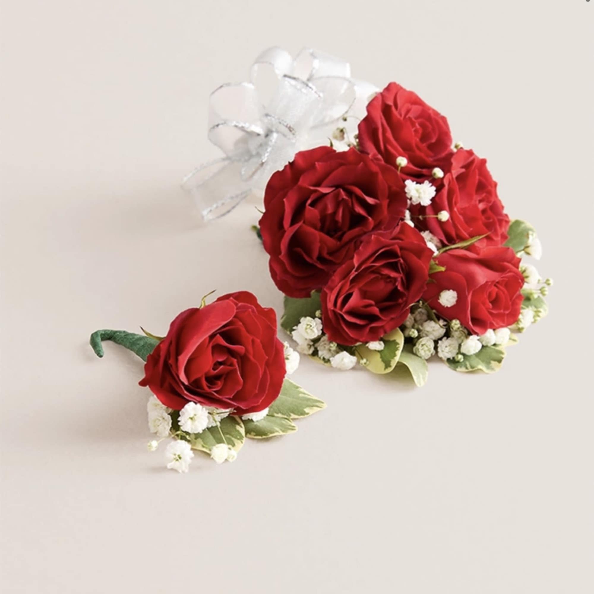 This elegant corsage and boutonniere set, featuring vibrant red blooms, is thoughtfully