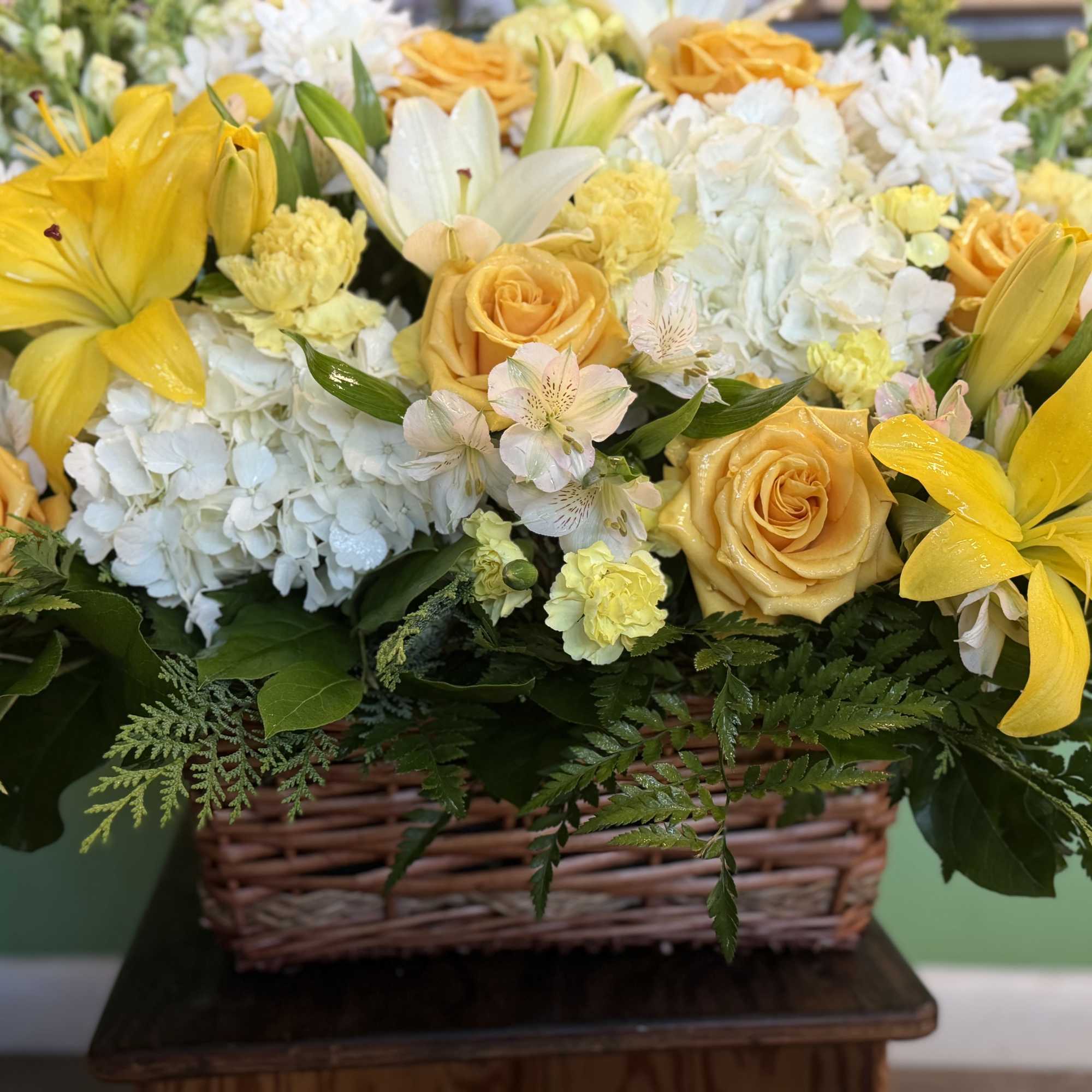 A woven basket overflows with a cheerful arrangement of yellow and white