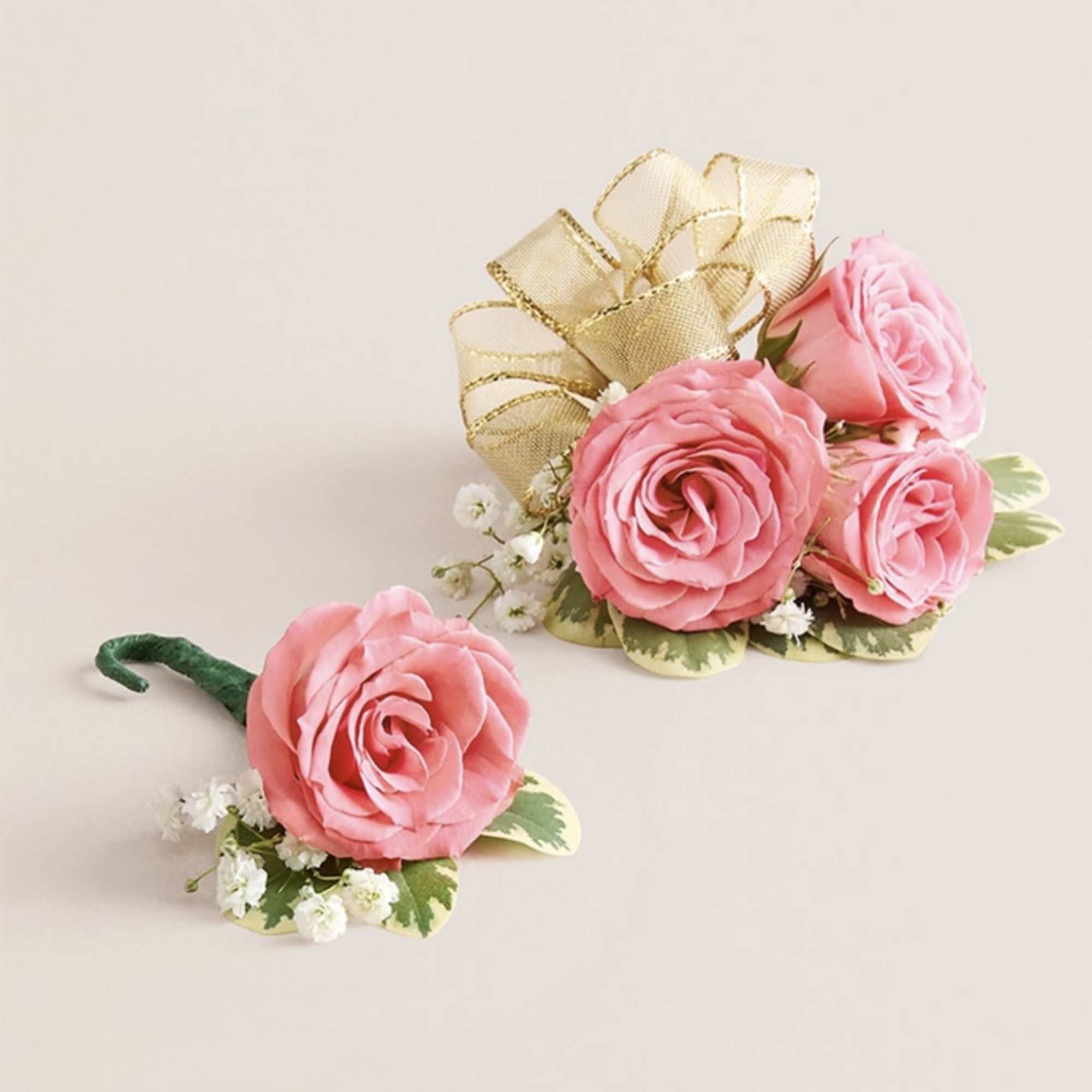 This striking corsage and boutonniere set, featuring delicate light pink blooms, is