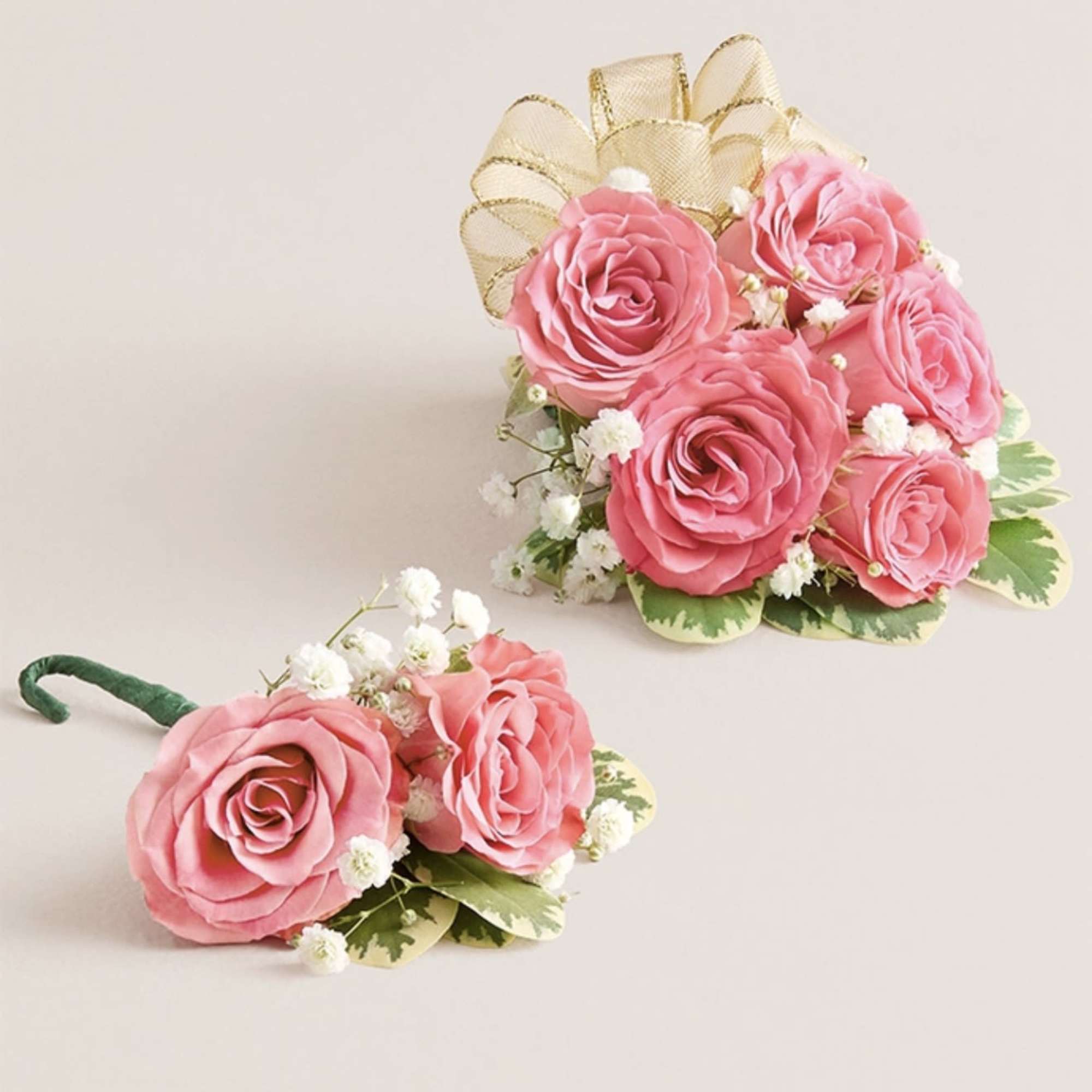This striking corsage and boutonniere set, featuring delicate light pink blooms, is