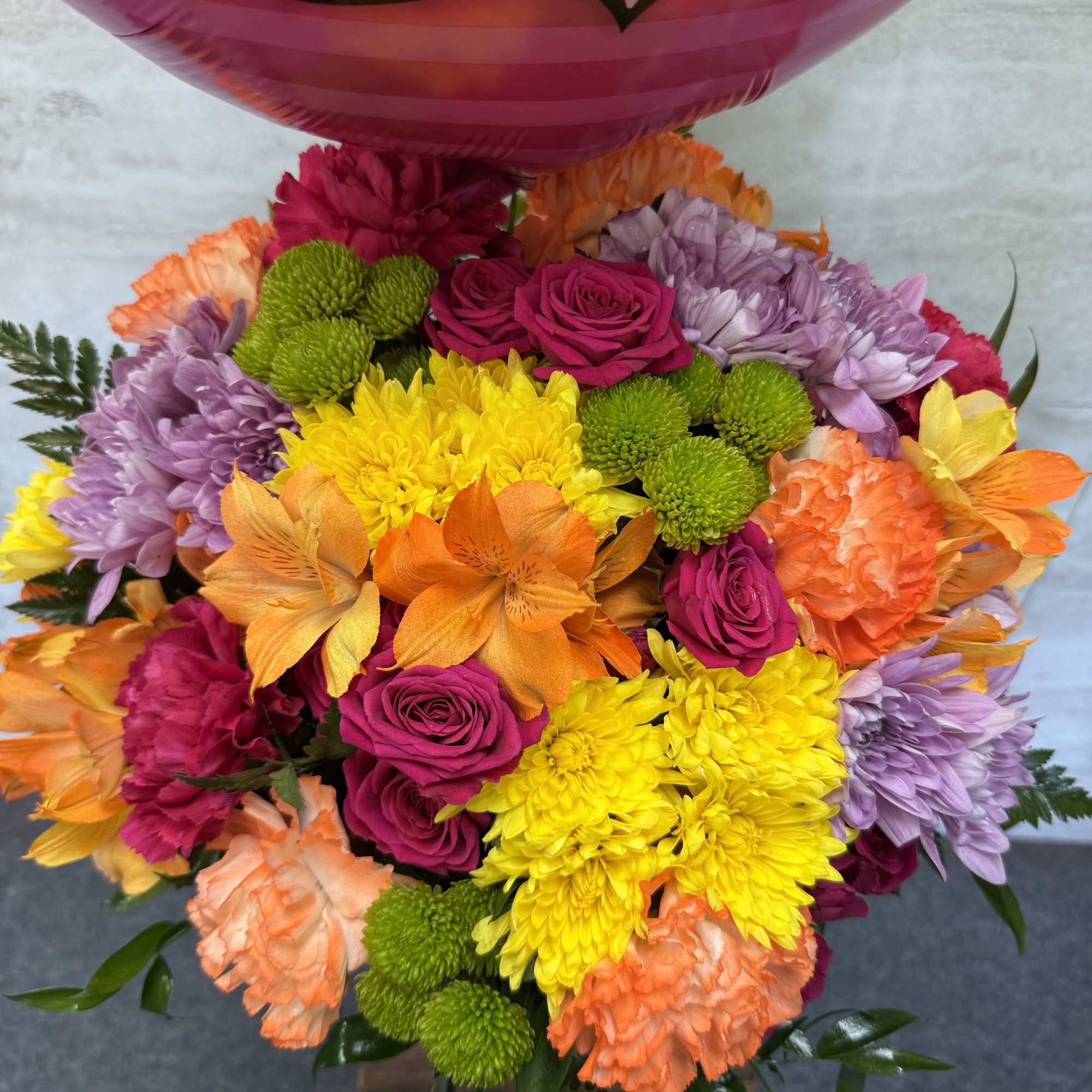 A bright, cheerful mix of colorful blooms designed to celebrate joy, happiness
