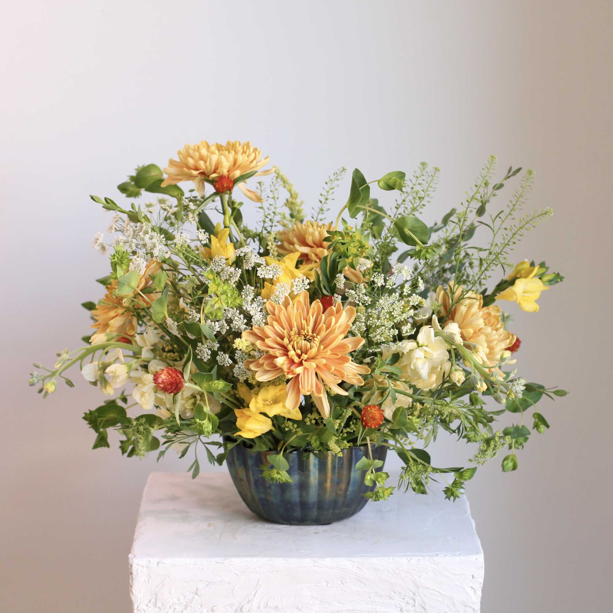 Meet &ldquo;Spring Oasis,&rdquo; a vibrant floral arrangement blending gold, fiery orange, and