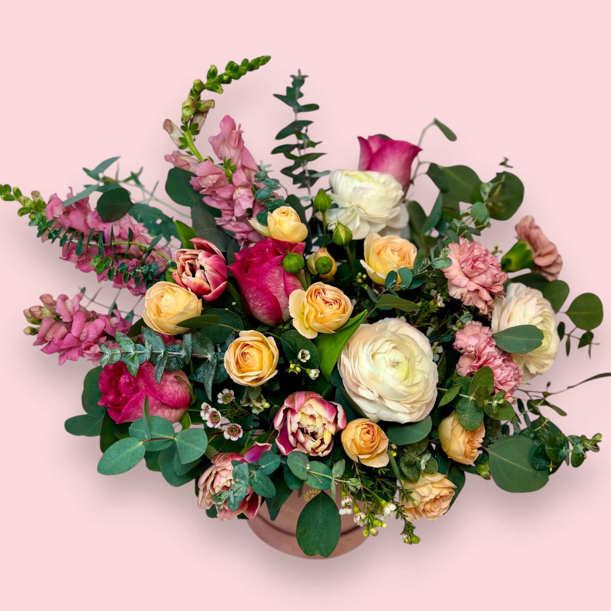 Mixed pink and cream flower arrangement in a round vase