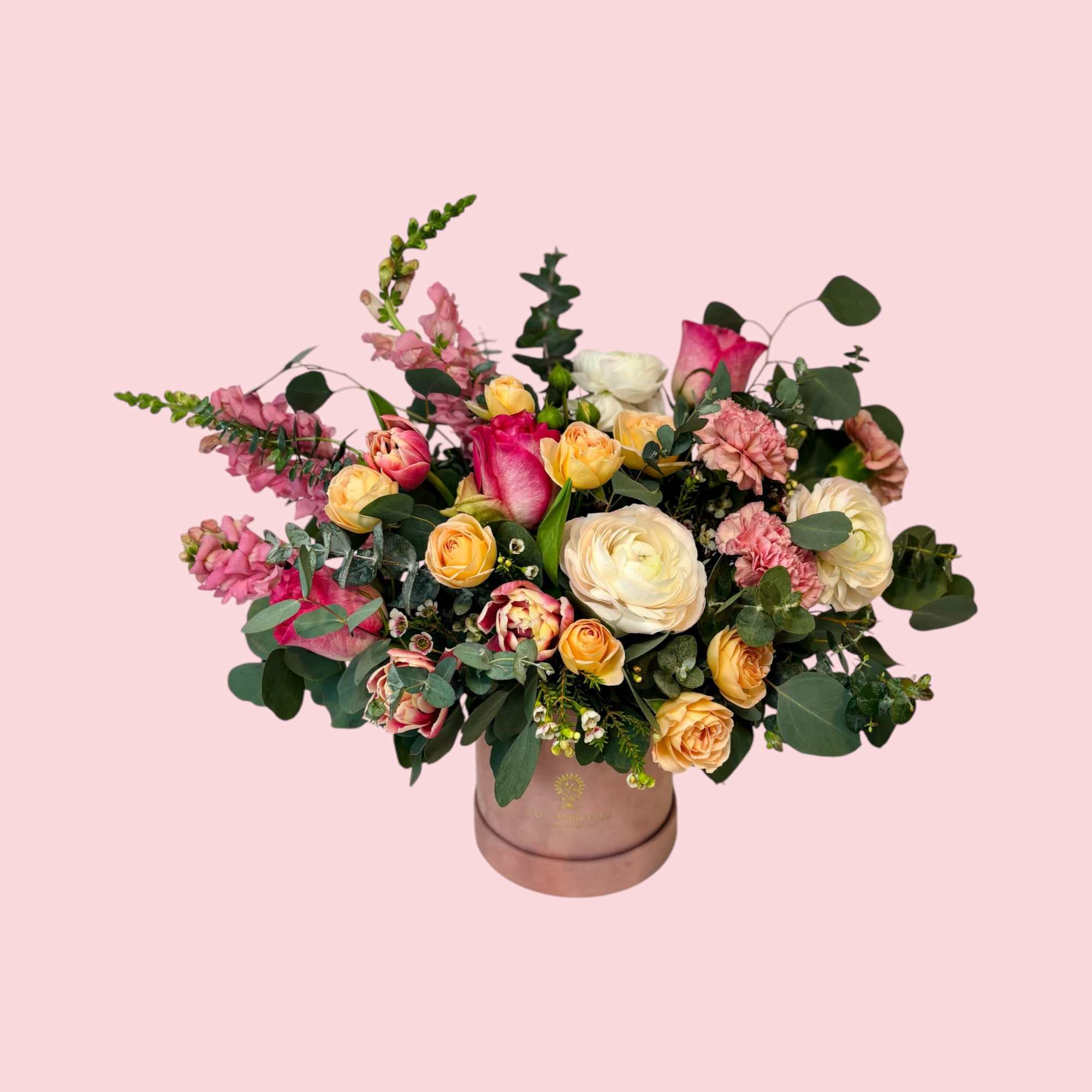 Mixed pink and cream flowers arranged in a round vase