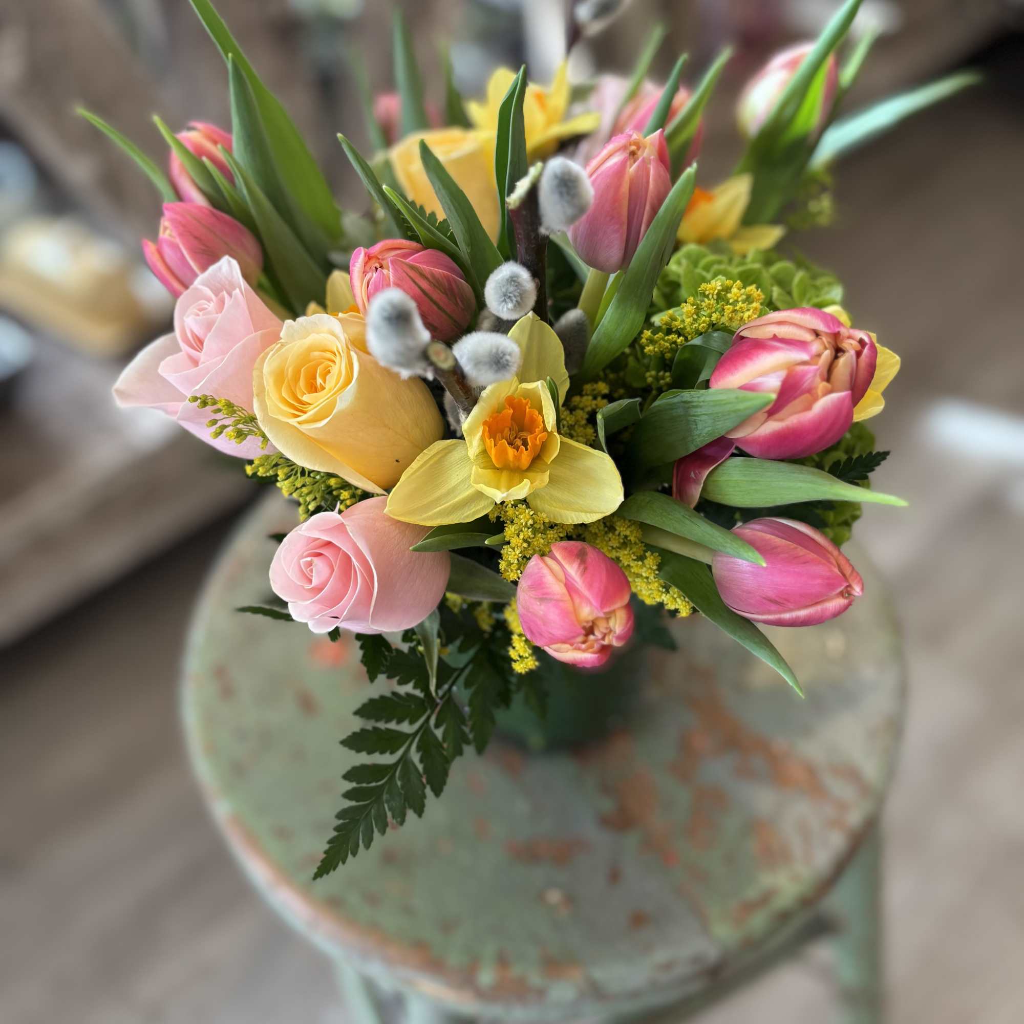 A bright and cheerful mix of blush roses, golden daffodills and fresh