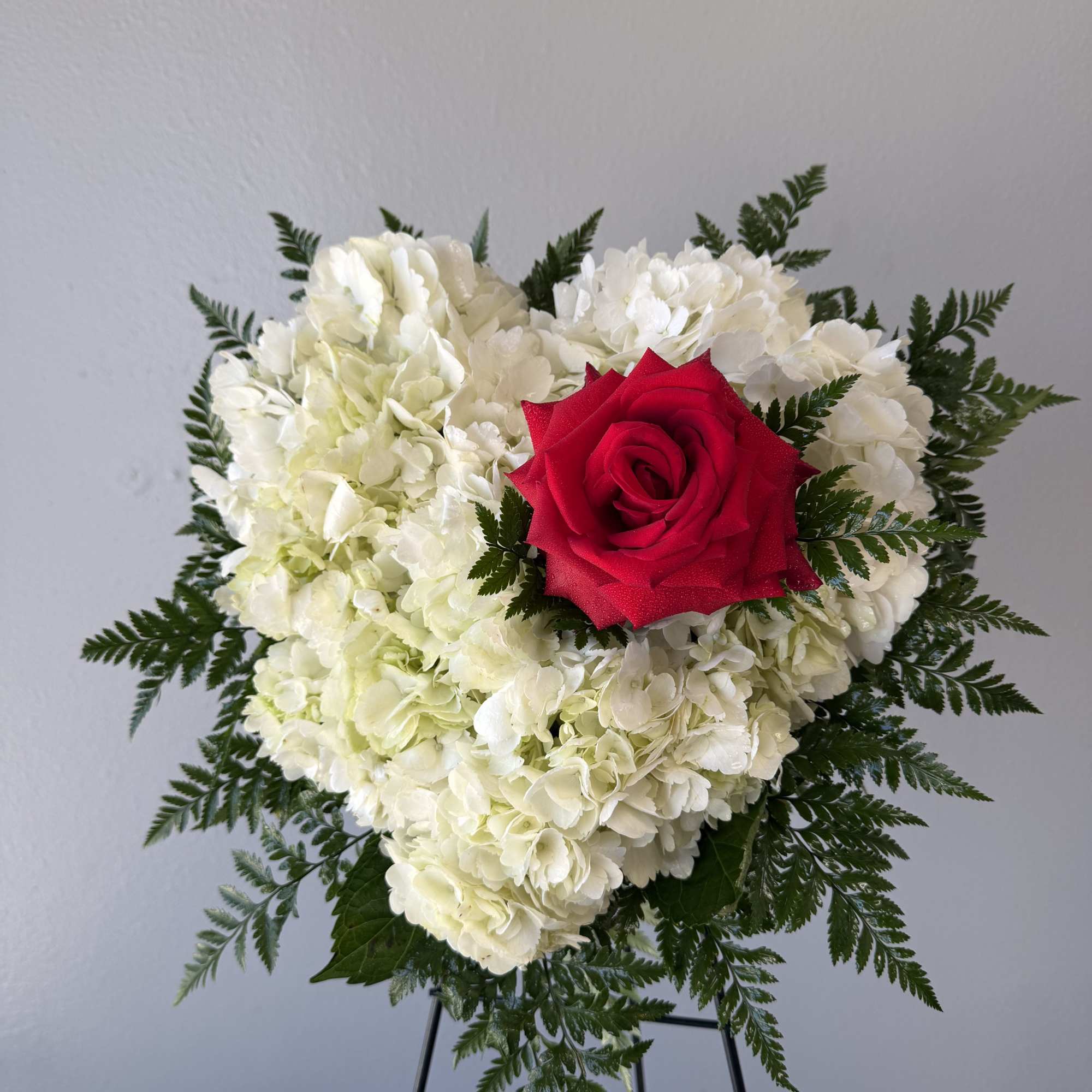 Mini heart on easel. A soft cushion of white hydrangeas shaped into
