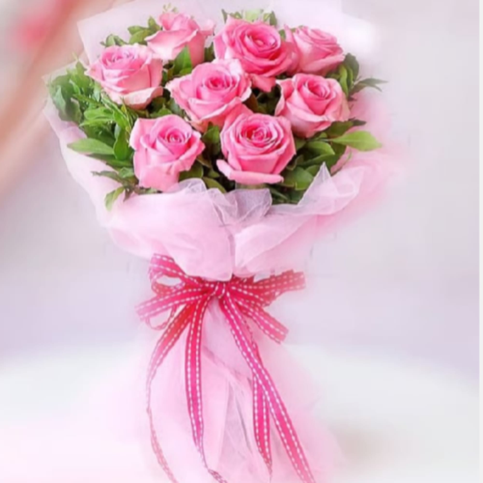 A lush dome of medium pink roses arranged in a tight, hand-tied