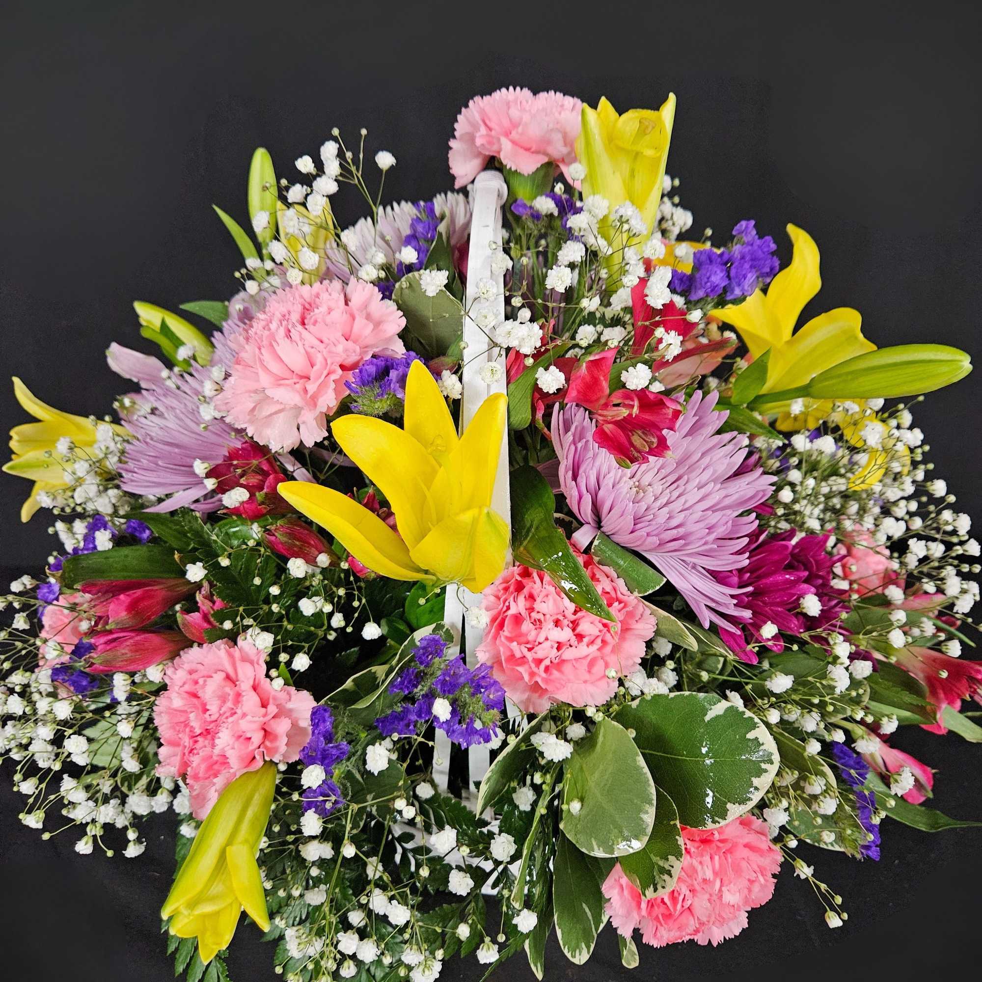 A basket of bright, colorful flowers to pick up anyone's spirits. Includes